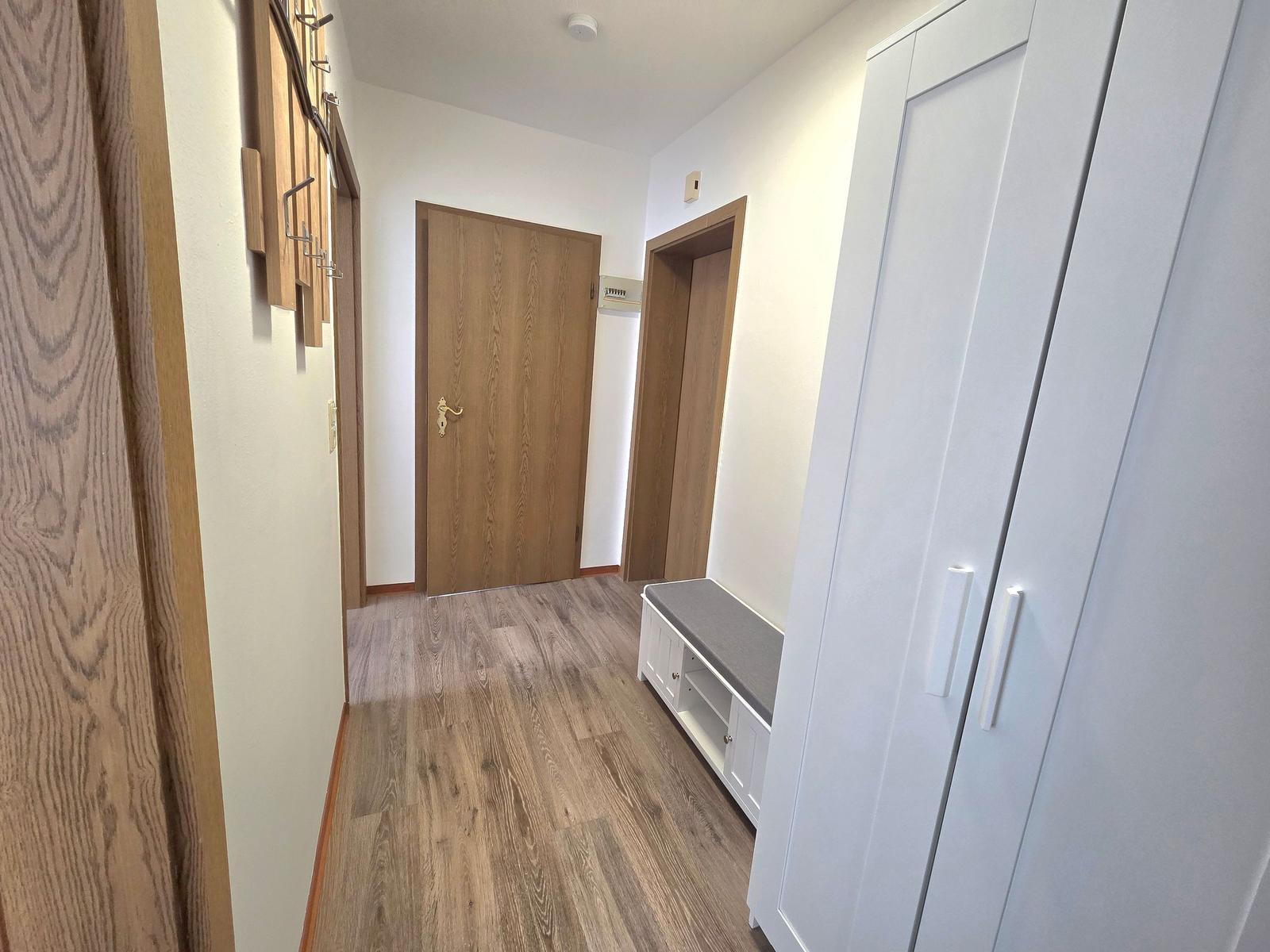 Flur mit Holzboden, Kleiderschrank und Sitzbank
