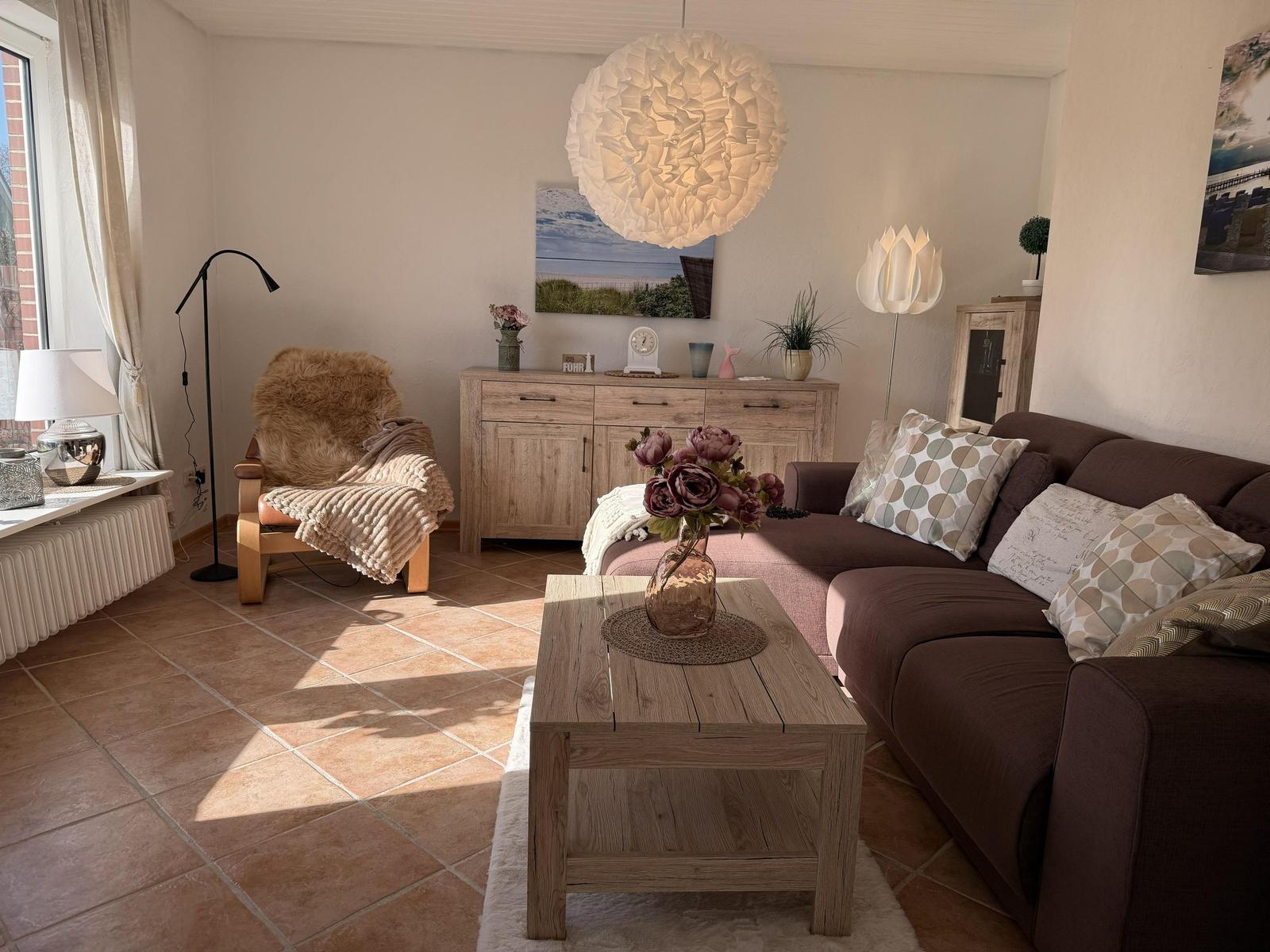 Wohnzimmer mit Sofa, Sessel, Holztisch und Decken