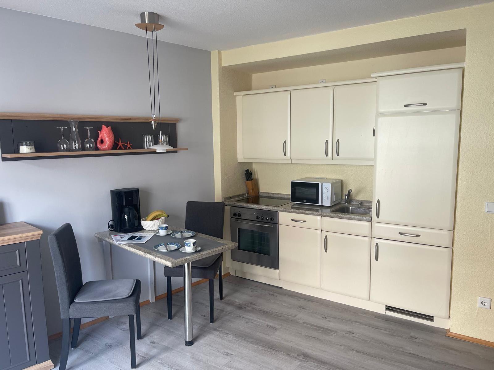 Küche mit Essbereich, Kühlschrank, Mikrowelle und Herd.