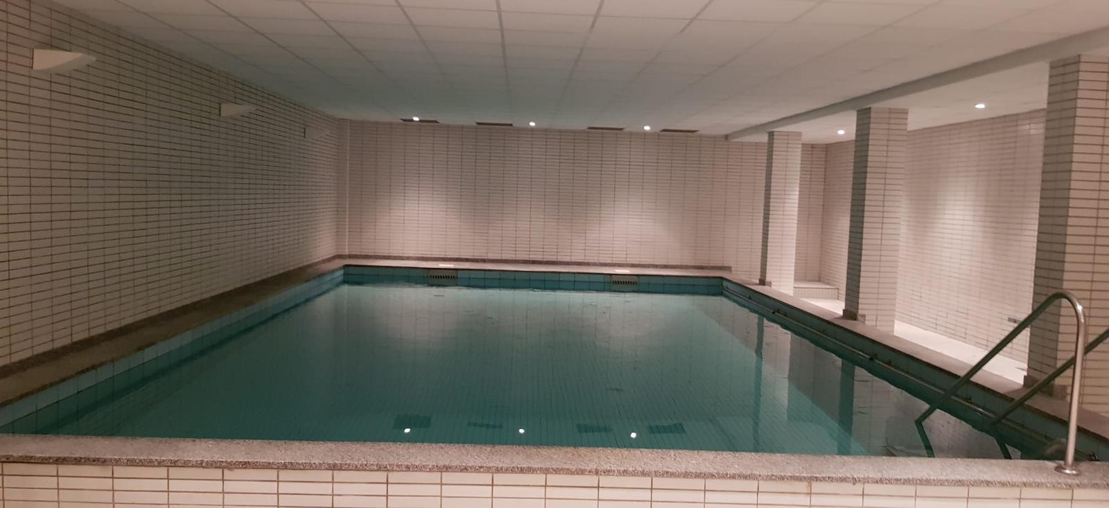 Innere Schwimmhalle mit tiefem Becken und Treppenaufgang