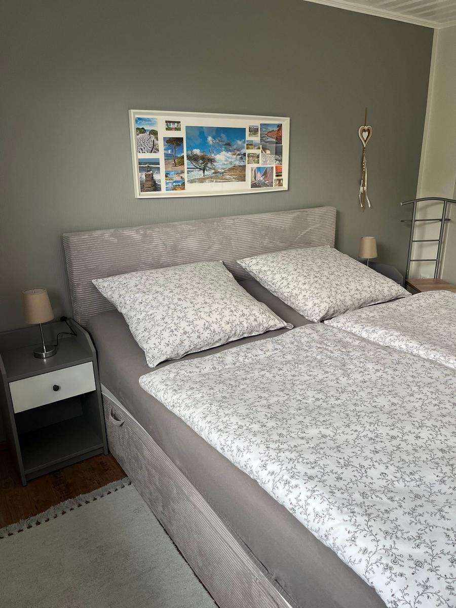 Bedroom with bed, nightstand, and wall picture.