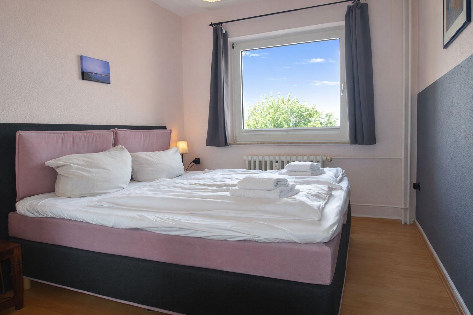 Schlafzimmer mit Bett, Fenster und Badewanne
