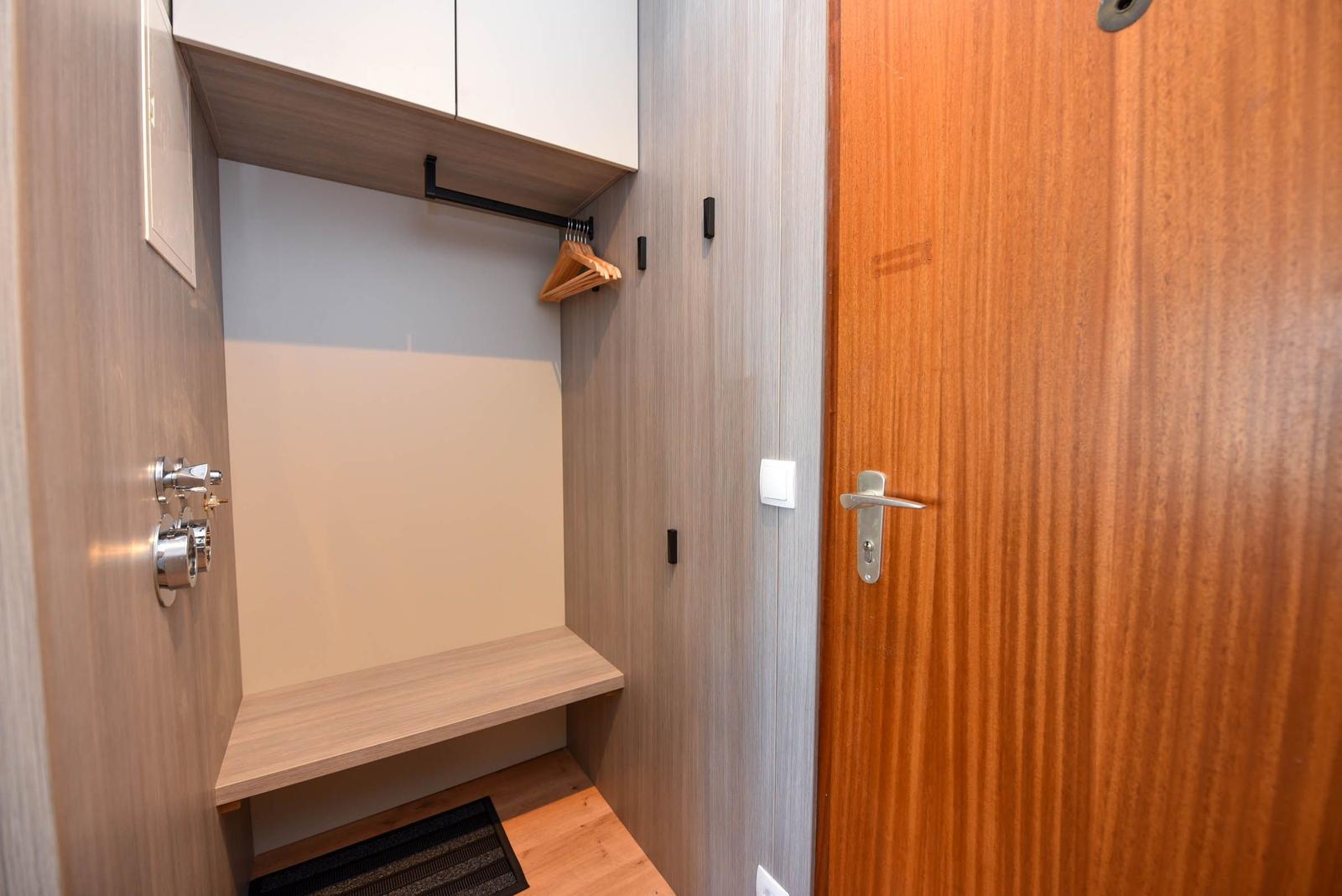 Schlafzimmer mit Kleiderschrank, Haken und Sitzbank