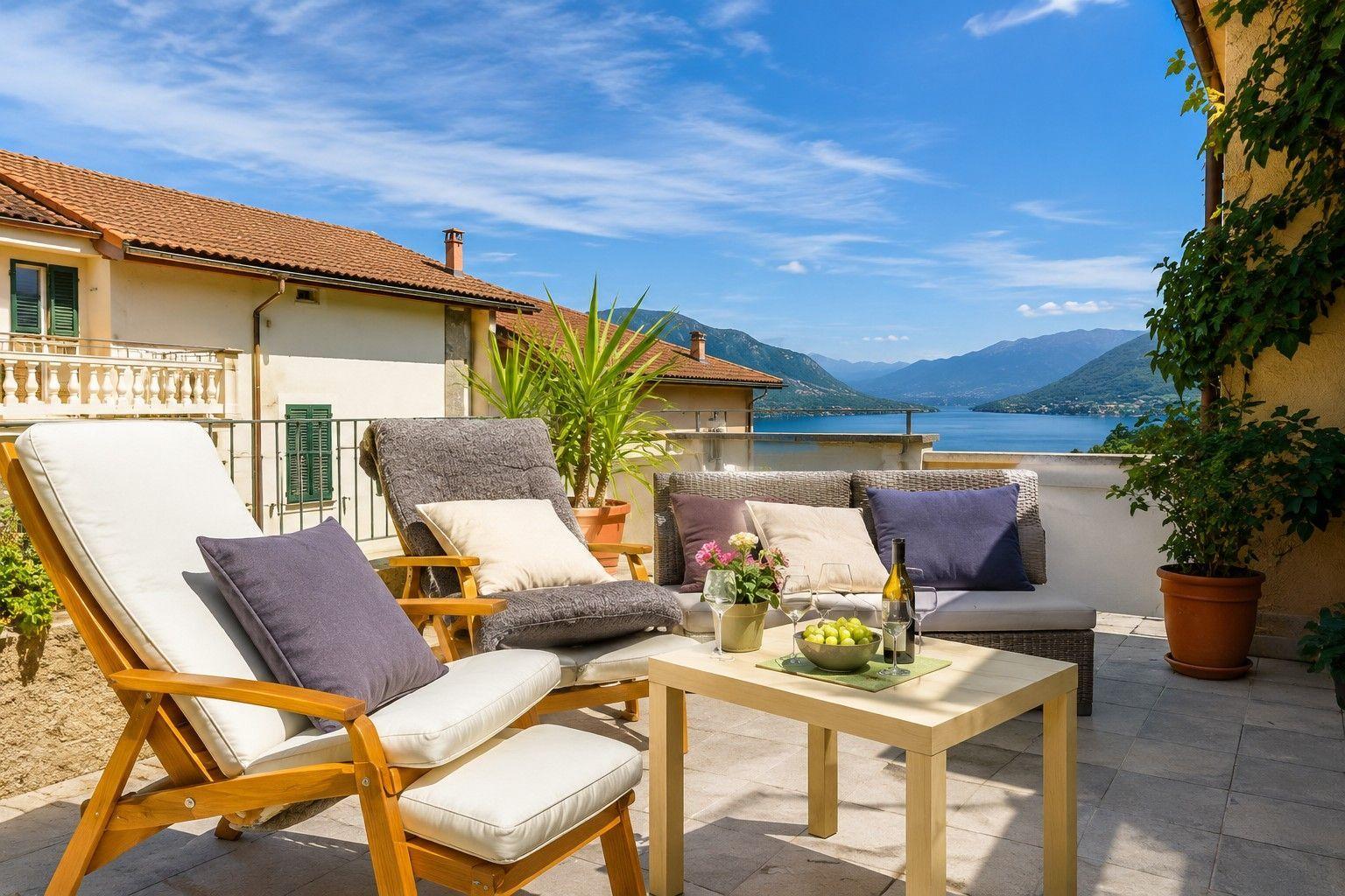 Terrace with seating and view of lake and mountains.