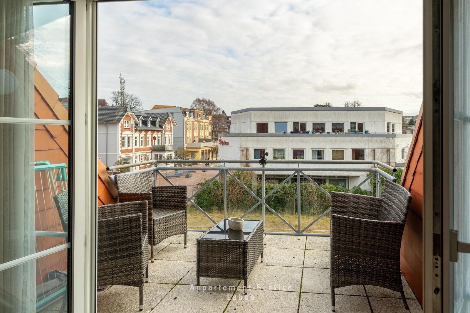 Terrasse mit Sitzgruppe und Blick auf Gebäude und Straße
