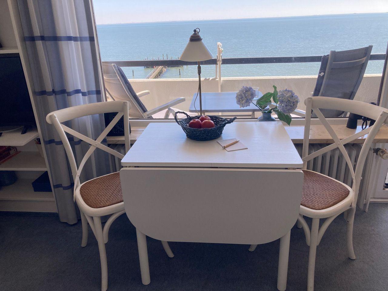 Dining area with table, chairs, and sea view