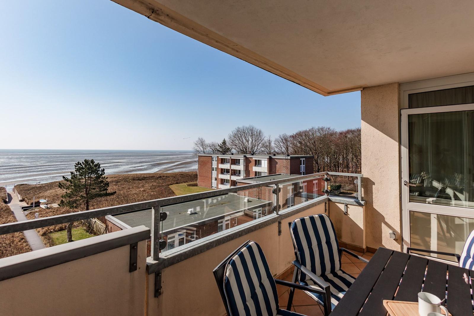 Terrace with seating and sea view towards the beach and ocean.