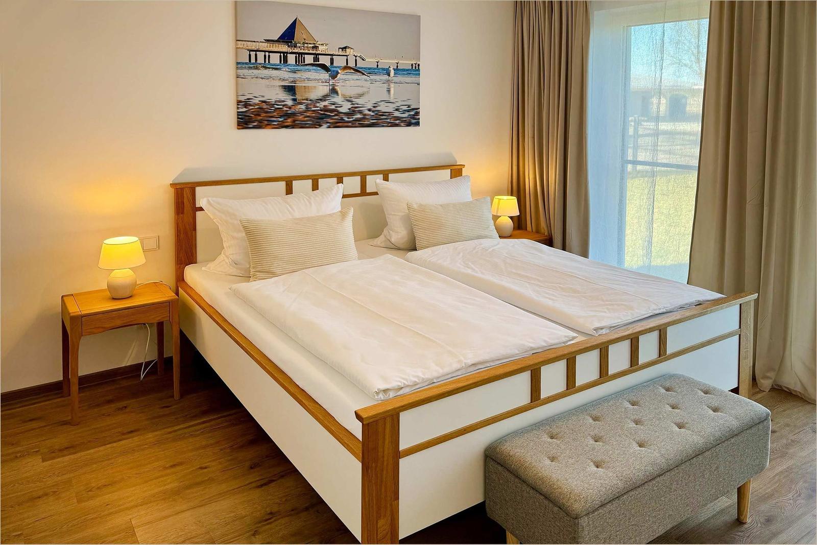 Schlafzimmer mit Doppelbett, zwei Nachttischen und Fenster mit Blick.
