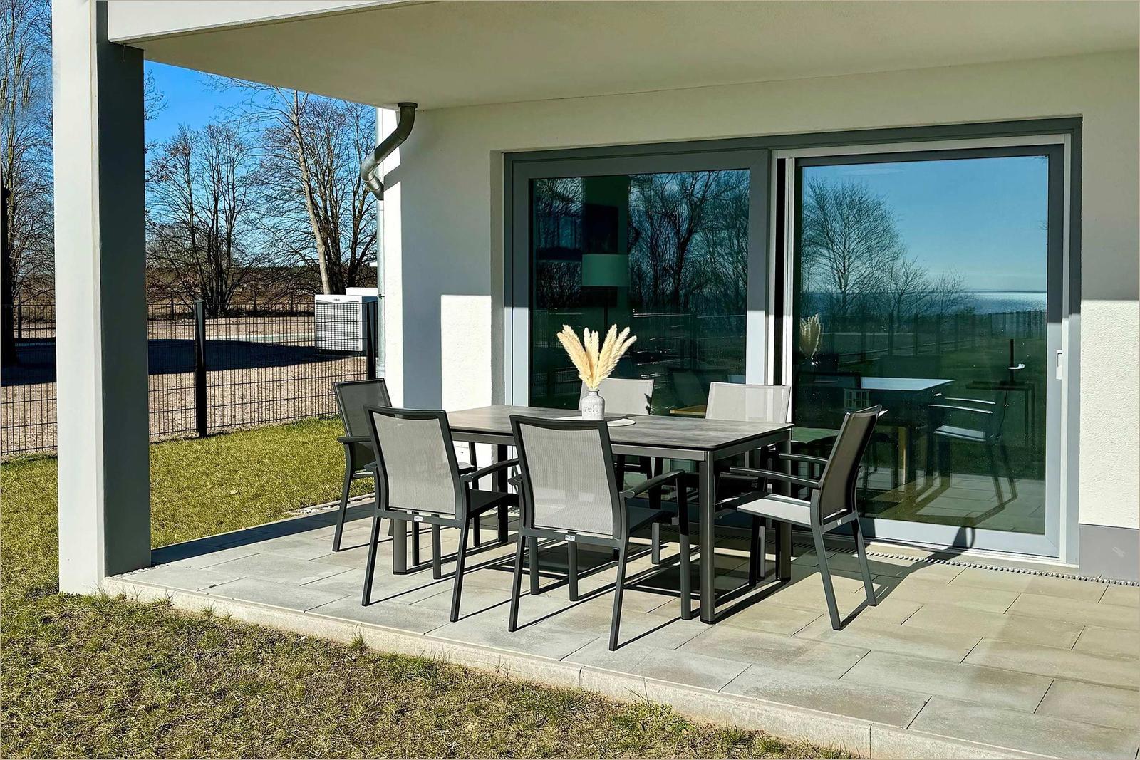 Terrasse mit Sitzgruppe und Glastüren zur Wohnung.