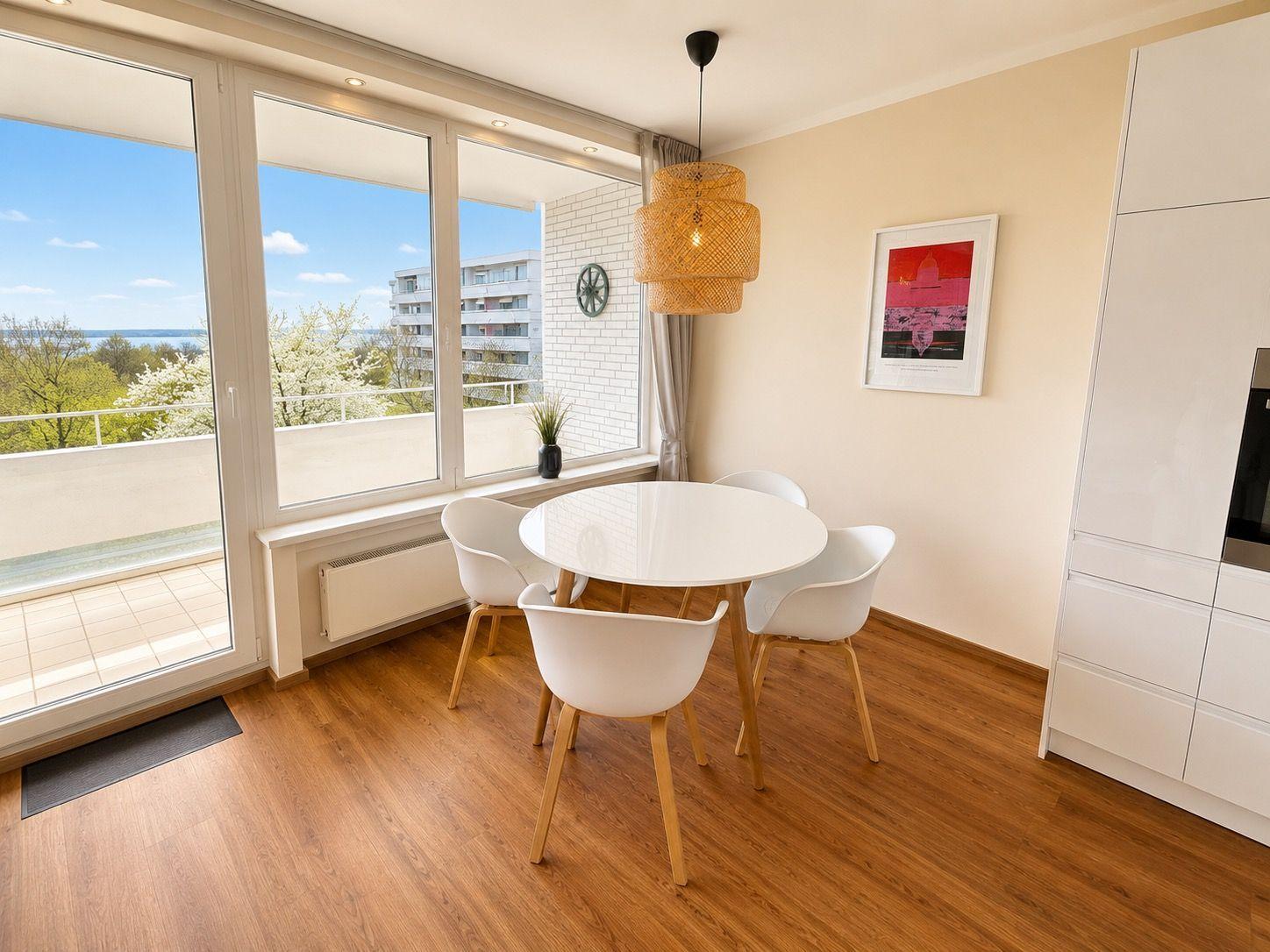 Dining room with round table, four chairs, and large window to terrace.