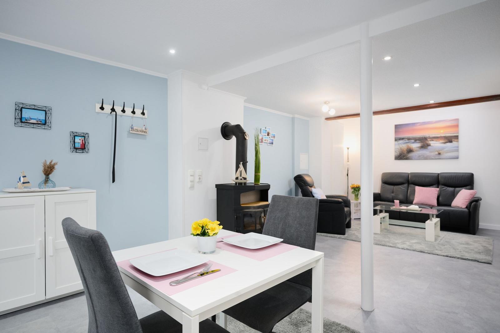 Essbereich mit Tisch und Stühlen. Wohnzimmer mit Sofa und Kamin.