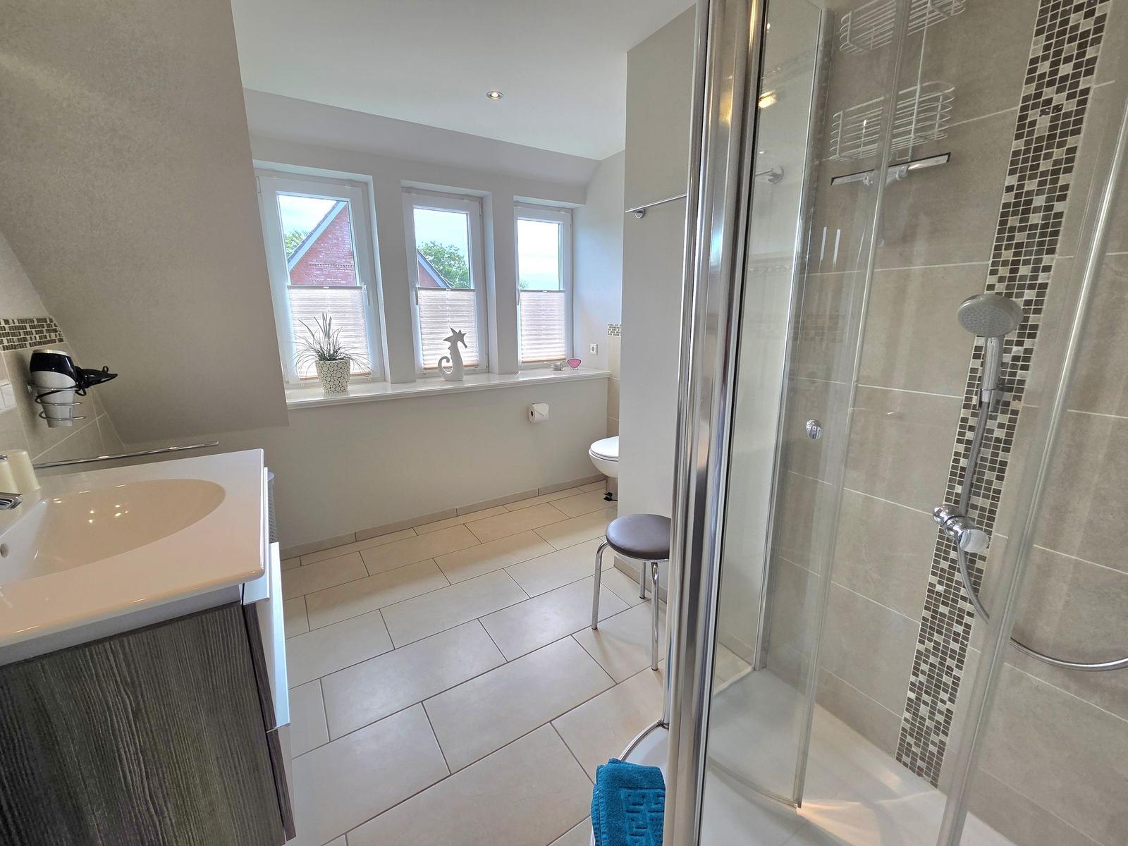 Bathroom with shower, sink, and windows
