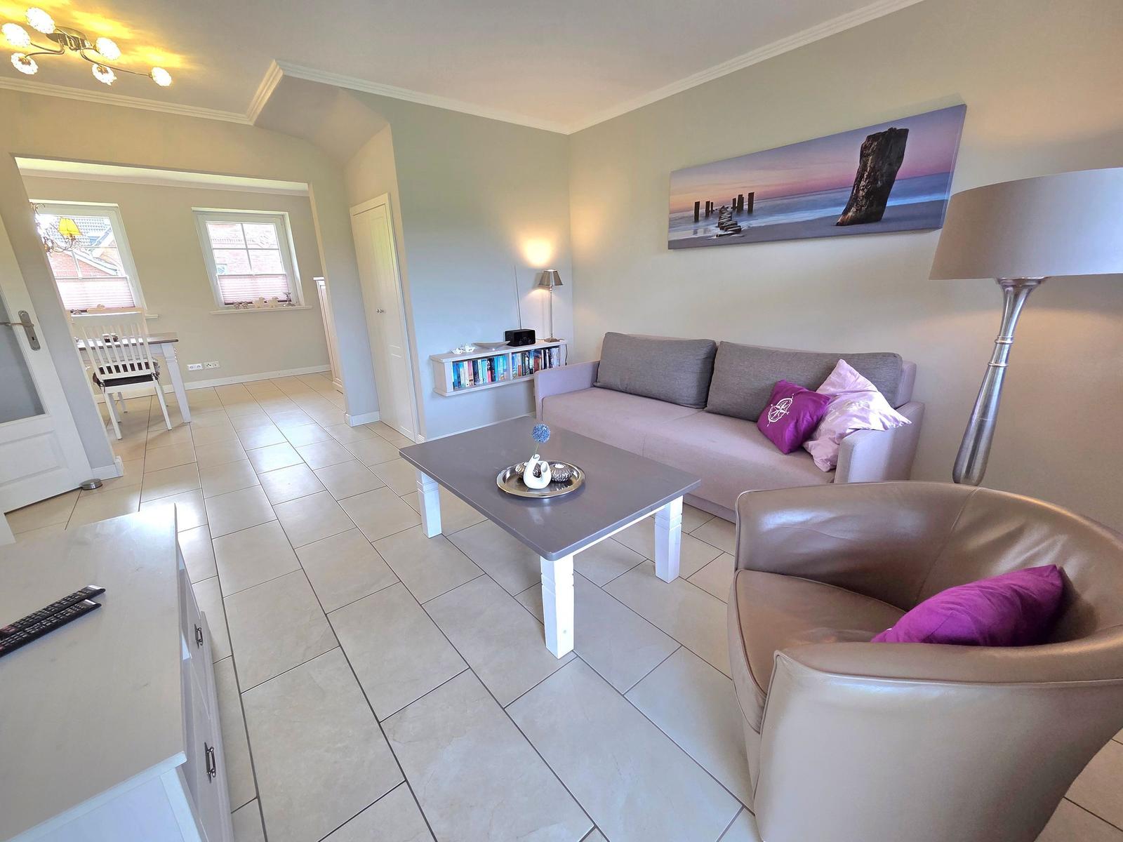 Living room with sofa, armchair, coffee table, and wall art.