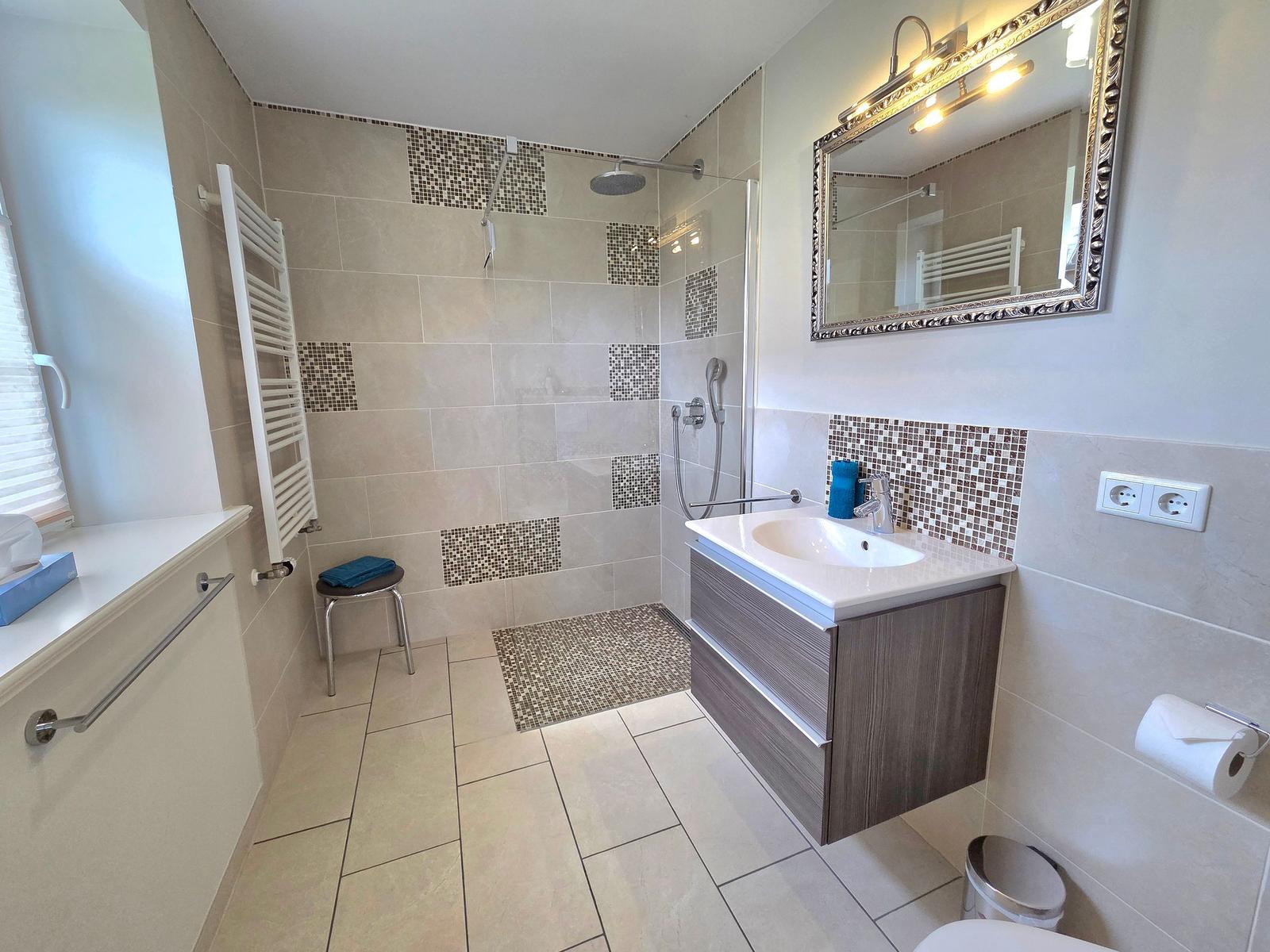 Bathroom with shower, sink, and mirror