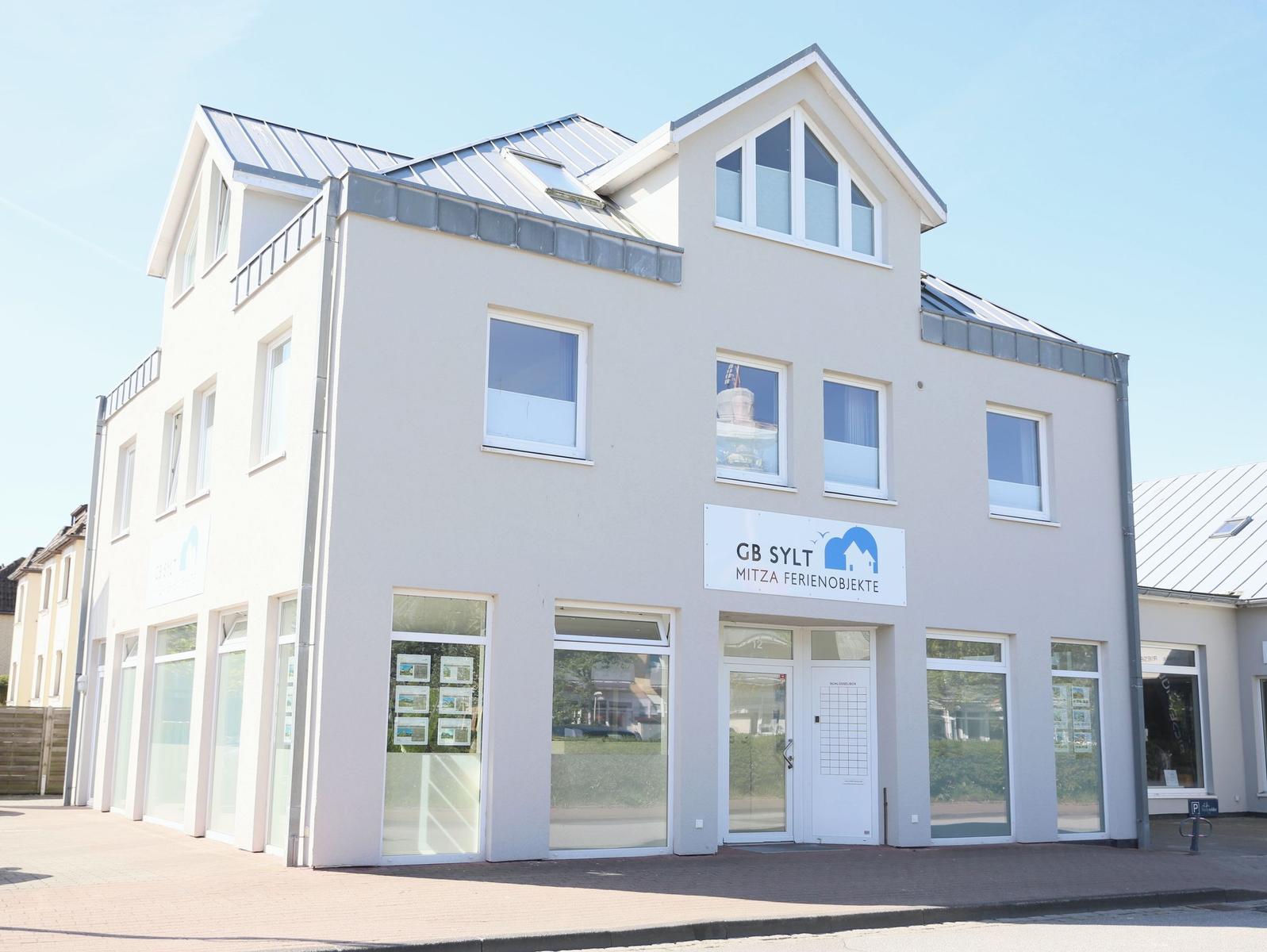 Modernes Gebäude mit Geschäftsfassade und Schild GB Sylt Ferienobjekte