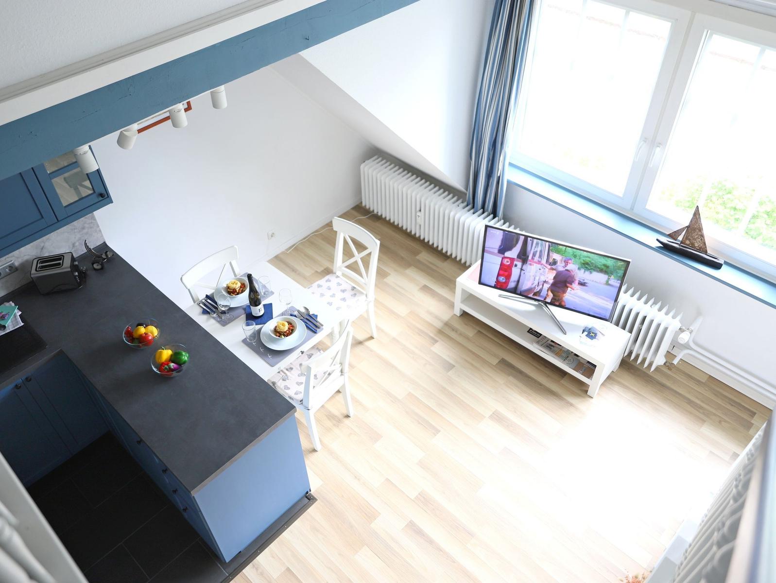 Küche mit Essbereich und Fernseher an der Wand.
