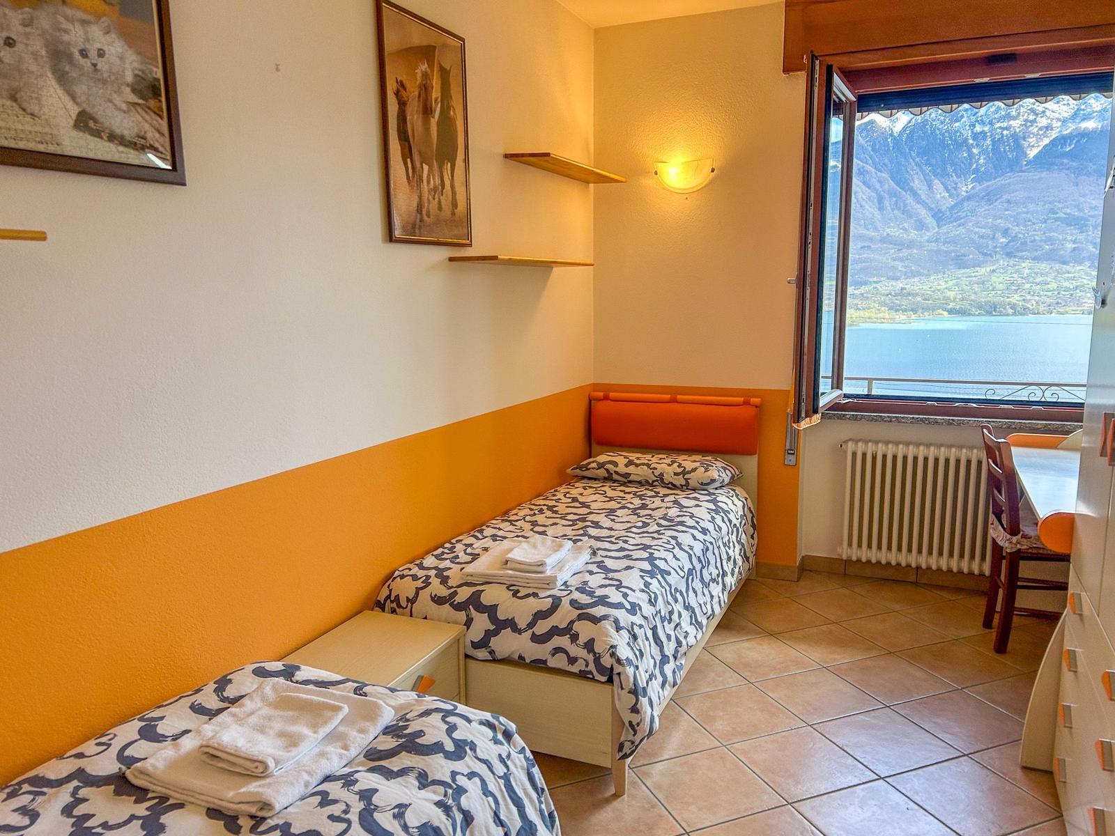 Schlafzimmer mit zwei Betten und großen Fenstern