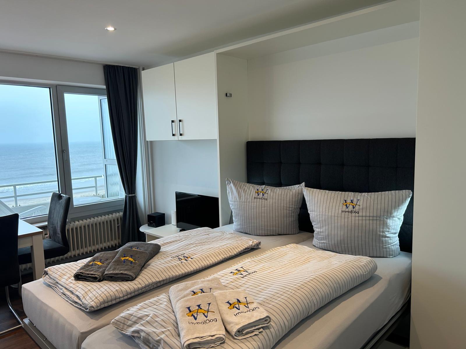 Schlafzimmer mit Blick aufs Meer und schwarzer Kopfseite