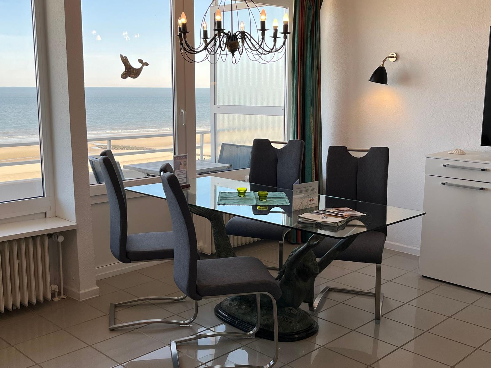 Esszimmer mit Glasplatte und Blick aufs Meer.
