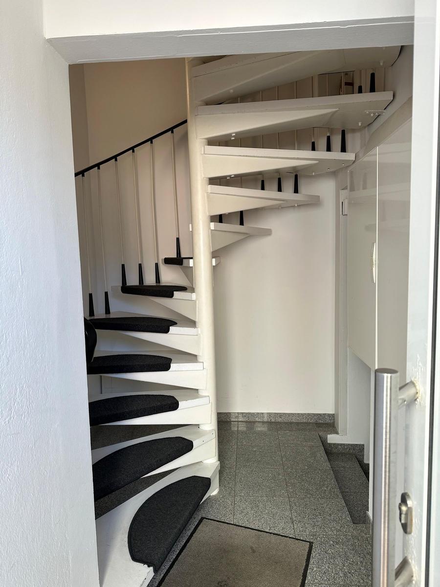 Höhenverstellbare Treppe mit schwarzem Teppich und Metallgeländer