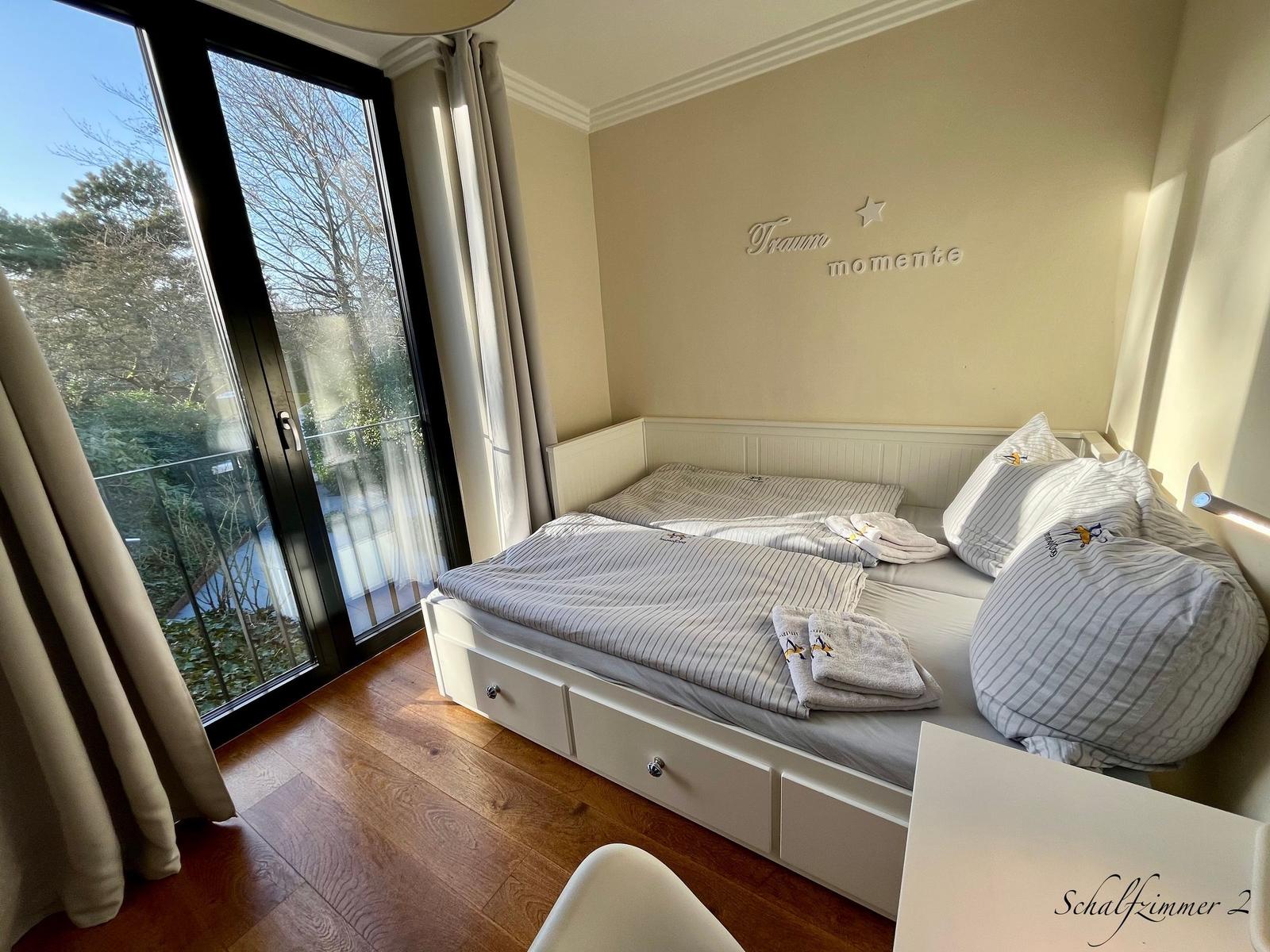 Schlafzimmer mit Doppelbett, Balkon und Wanddekoration.