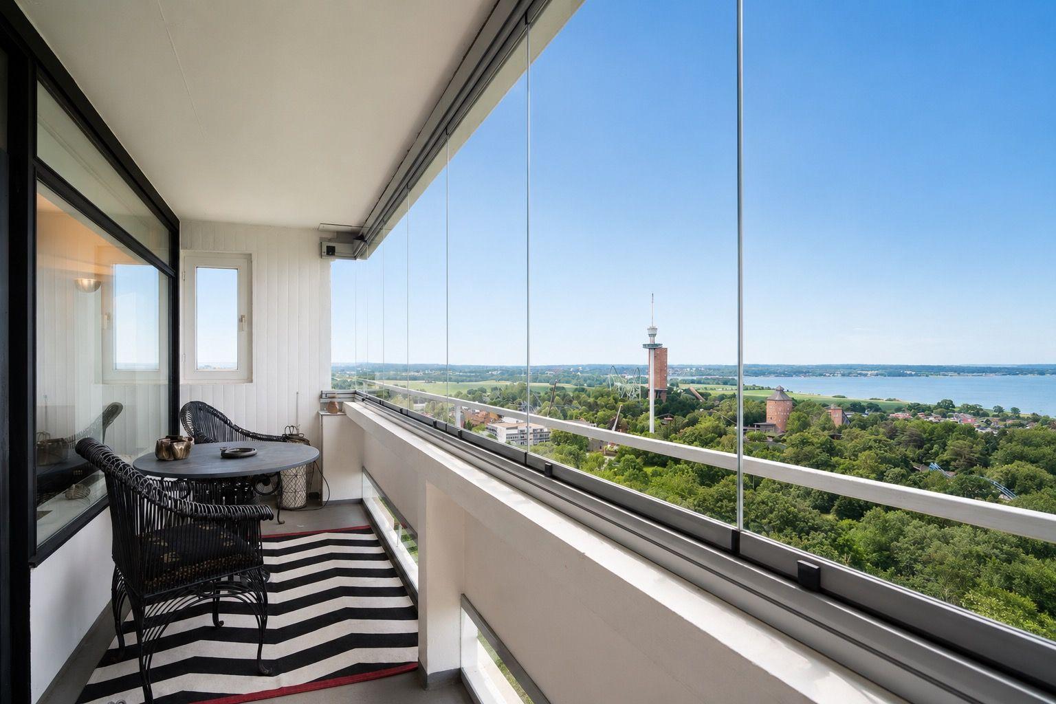 Balcony with seating area and view of lake and city