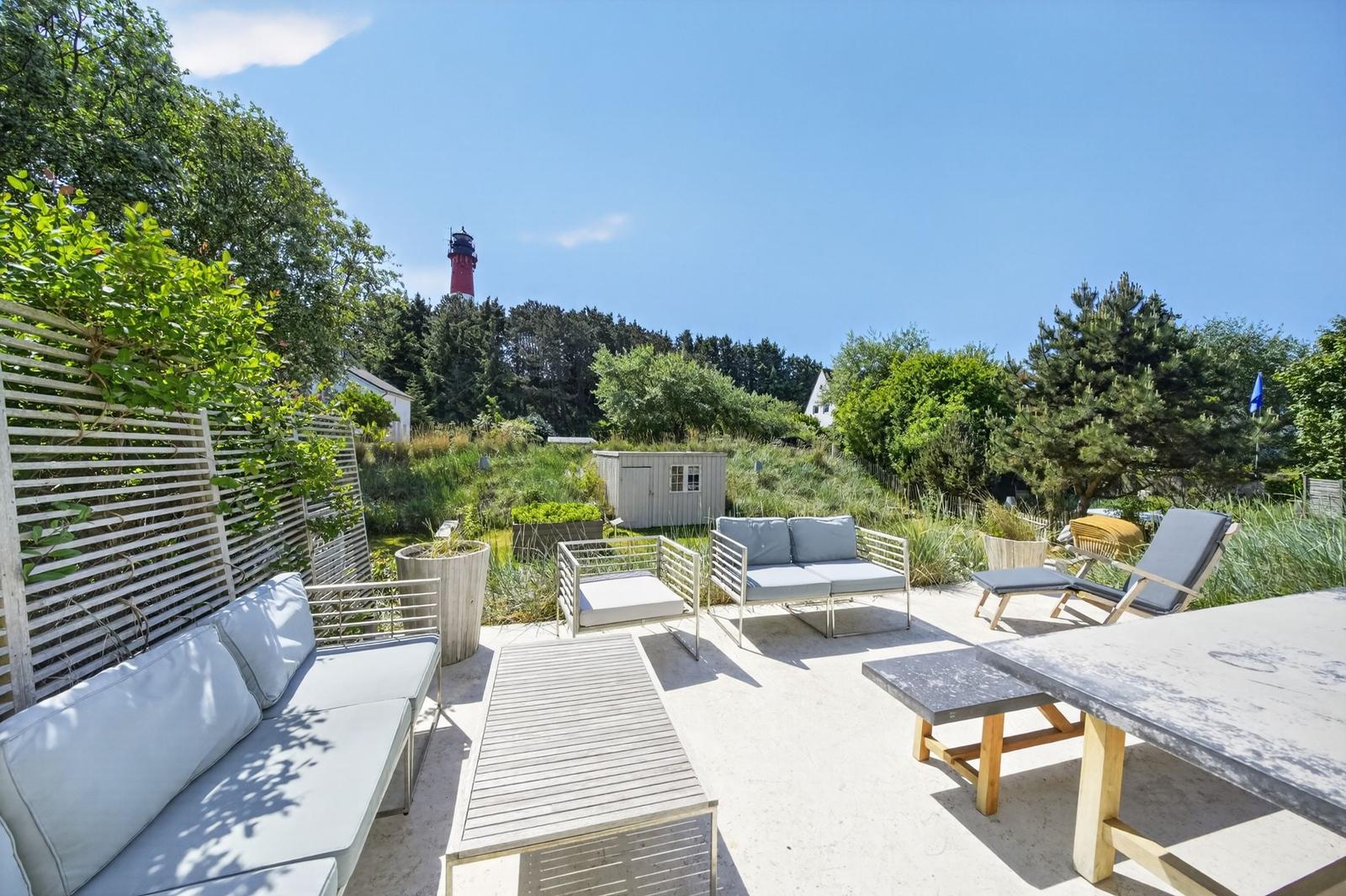 Terrasse mit Sitzgelegenheiten und Blick auf Leuchtturm.