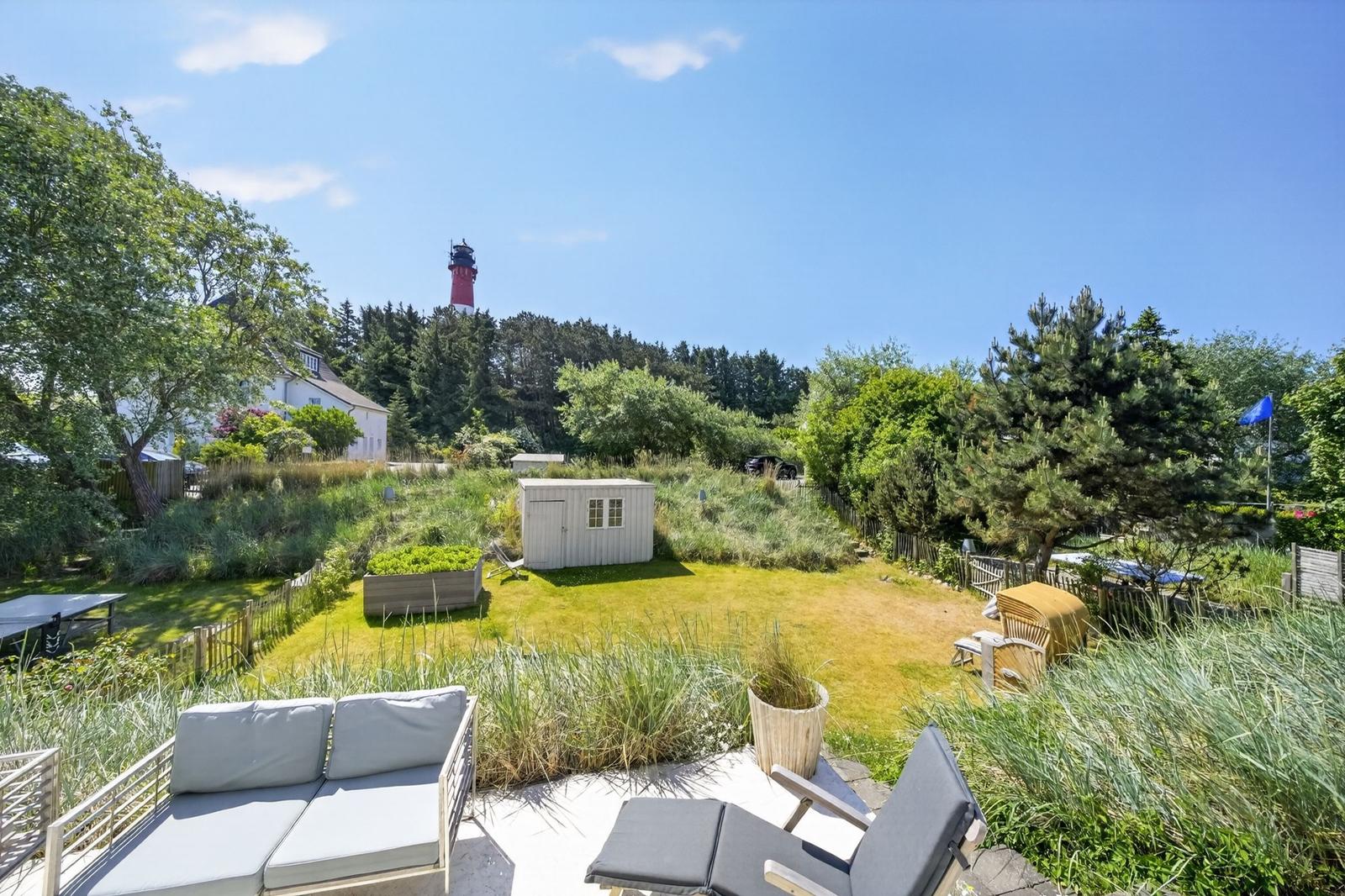 Hinterhof mit Garten, Liegen und Blick auf Leuchtturm.