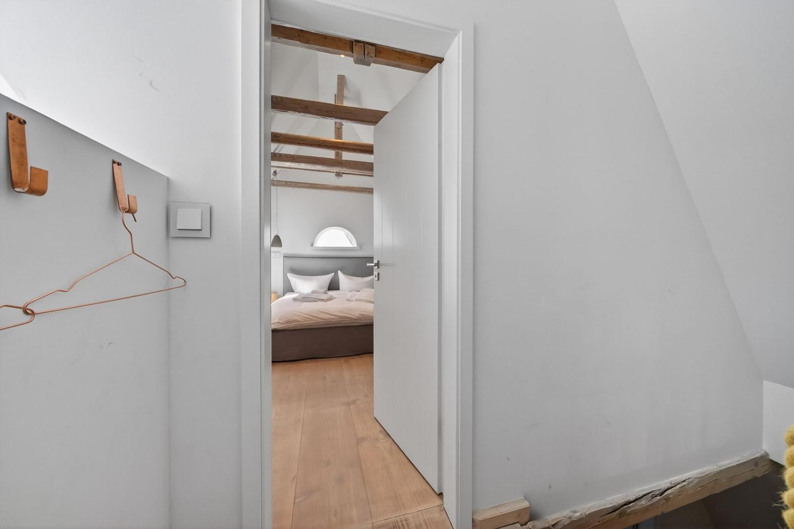 Durchgang in Schlafzimmer mit Holzboden und Dachschrägen
