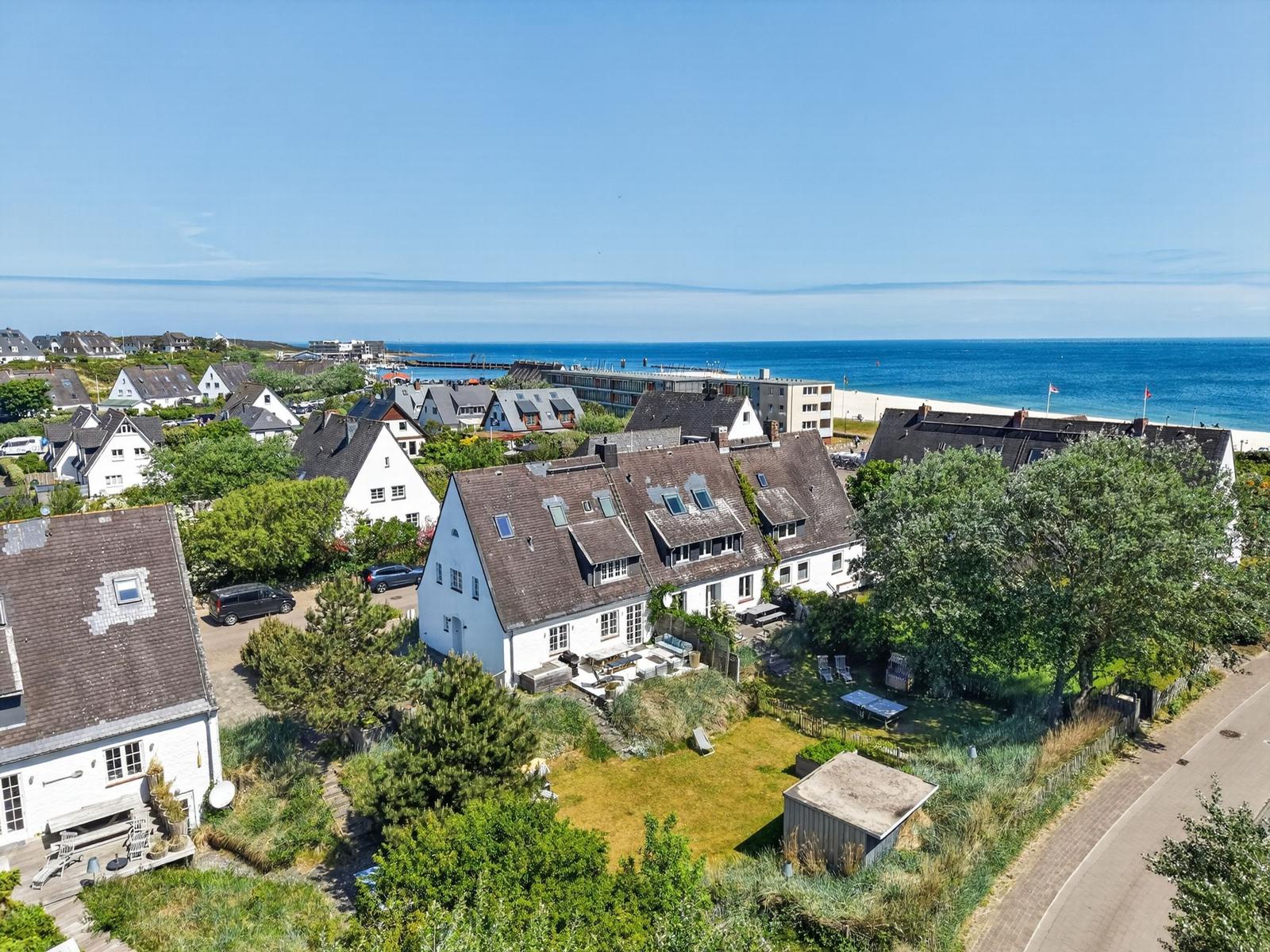 Haus mit Garten und Meerblick. Blick auf Strand und Hafen.