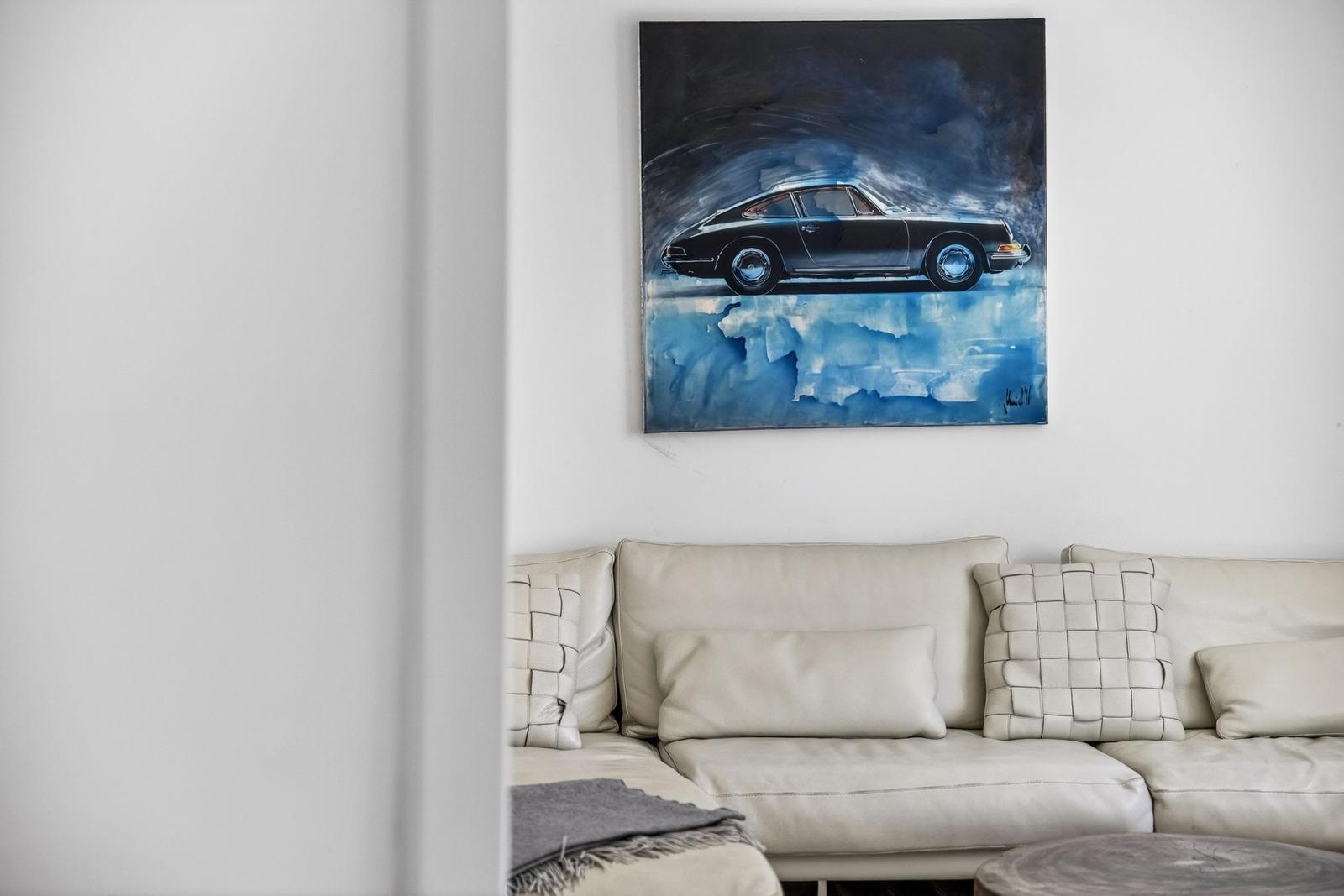 Ein Sofa mit Kissen und ein Bild an der Wand.
