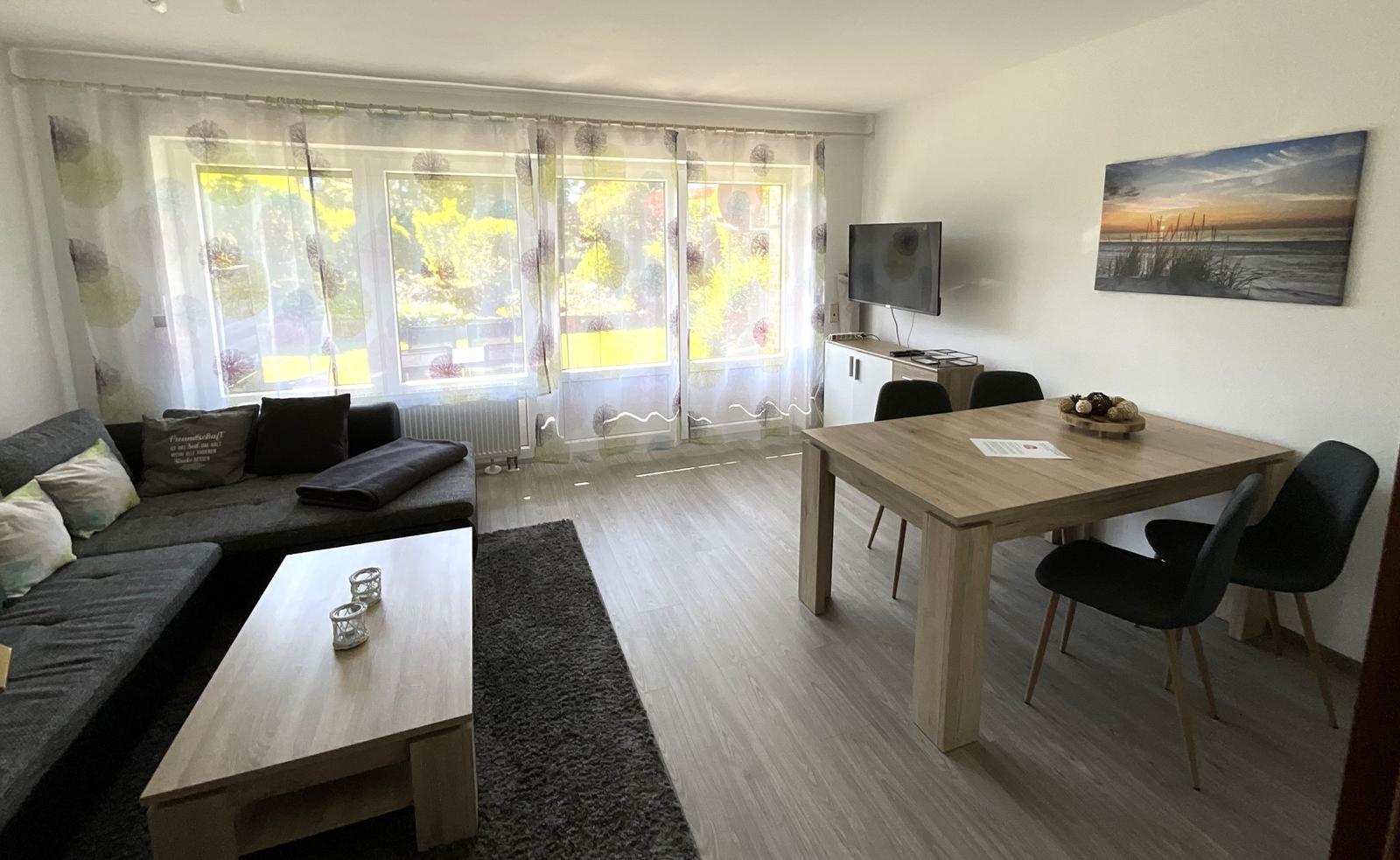Wohn- und Essbereich mit Sofa, Esstisch und TV.
