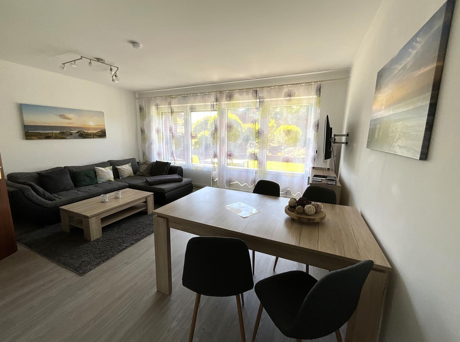 Wohn- und Essbereich mit Sofa, Esstisch und Blick auf Garten