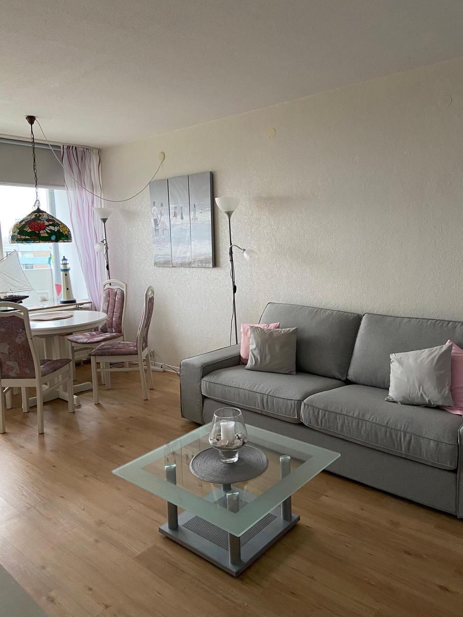 Wohn- und Essbereich mit Sofa, Glas-Tisch und Essgruppe.