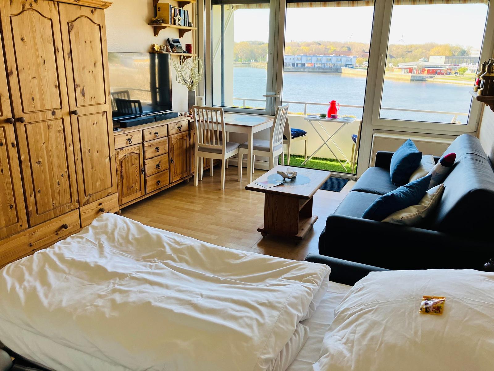 Zimmer mit Blick auf Wasser, Sofa, Tisch und Bett