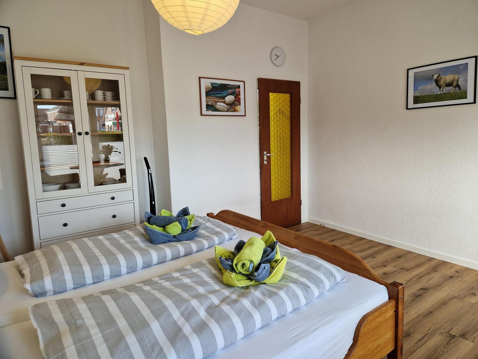 Schlafzimmer mit Doppelbett, Schrank und Tür mit gelbem Glas