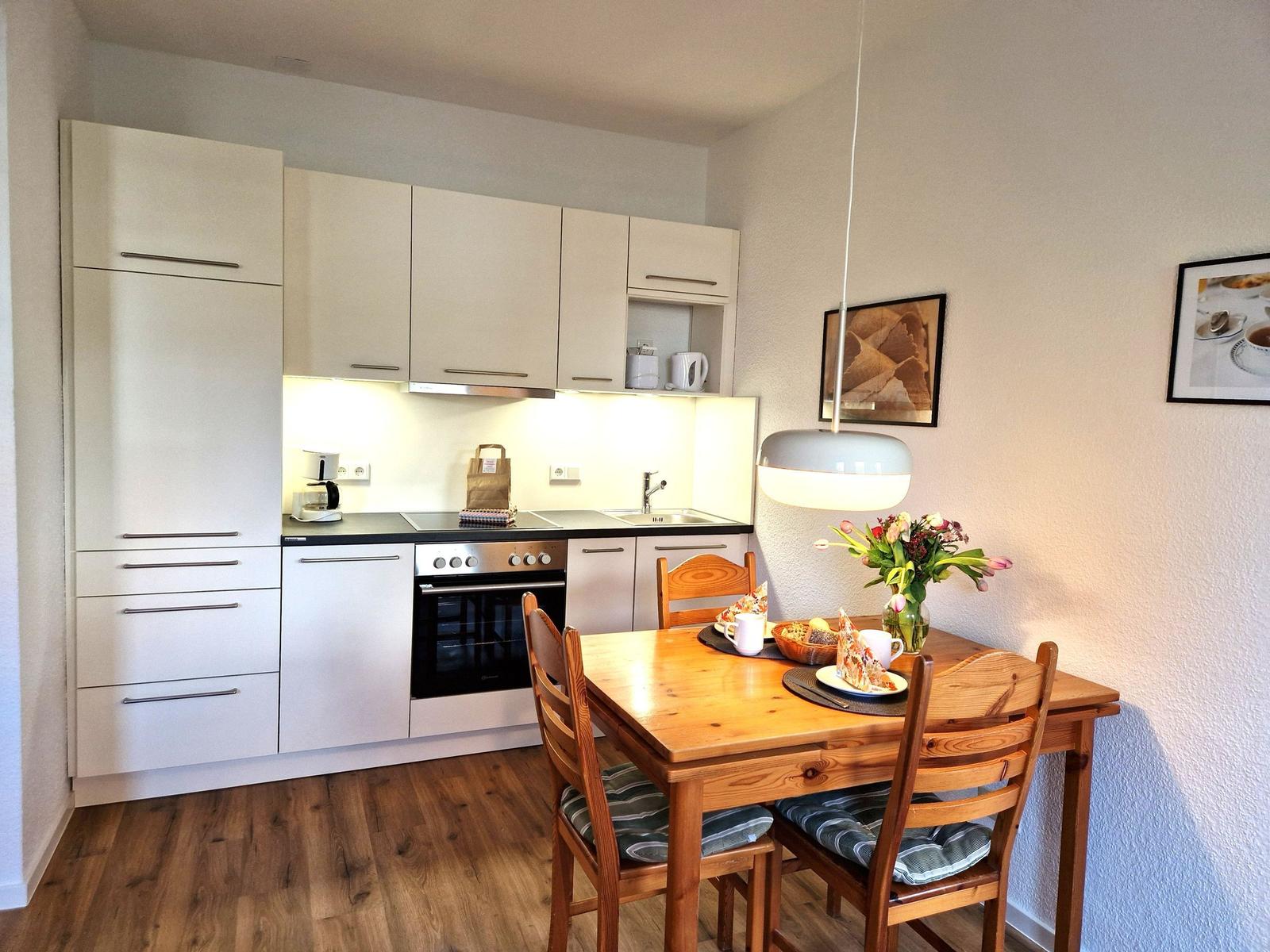 Kitchen with dining area, wooden table, chairs, and cabinets.