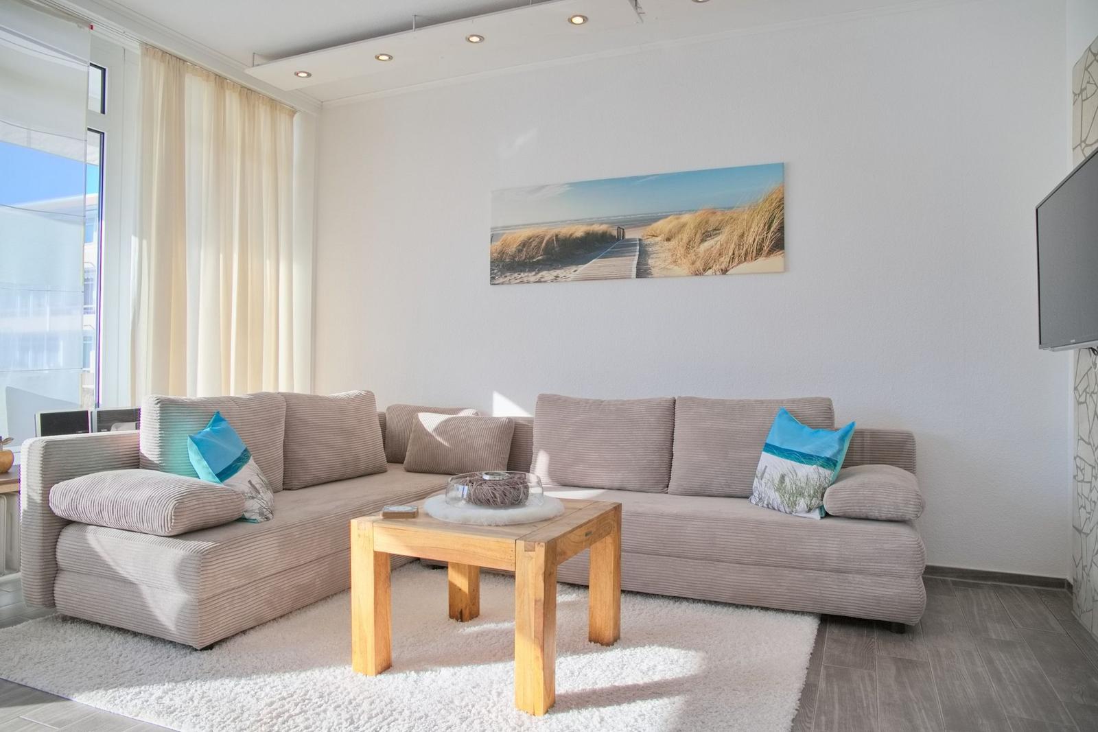 Ein Wohnzimmer mit einem großen Sofa, einem Holztisch und einer Wanddekoration.
