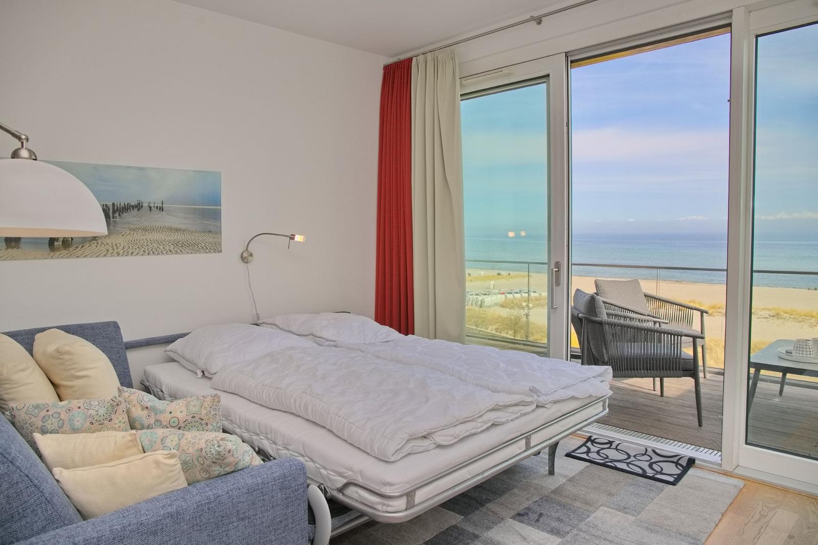 Schlafzimmer mit Blick auf den Strand und das Meer. Balkon mit Sitzgelegenheiten.