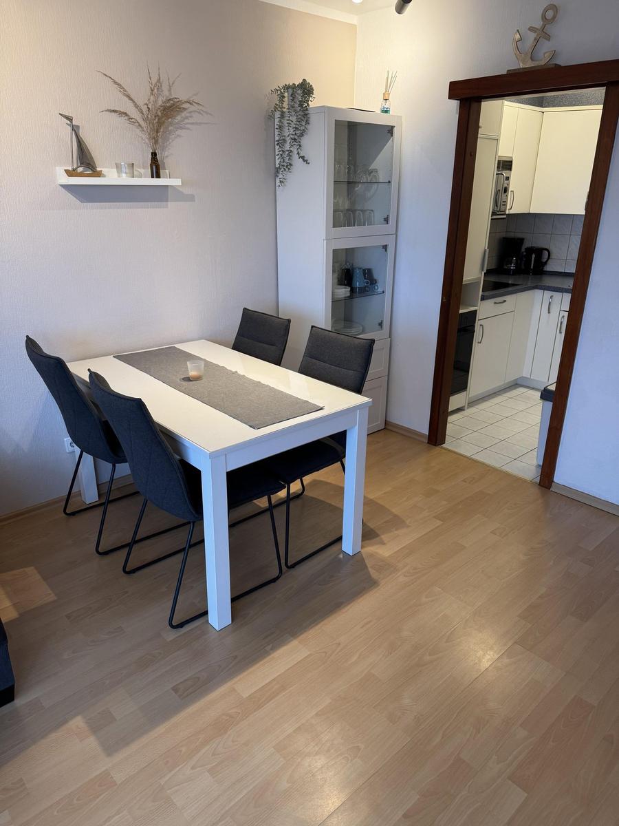 Essbereich mit Tisch und Stühlen, Küchenbereich im Hintergrund