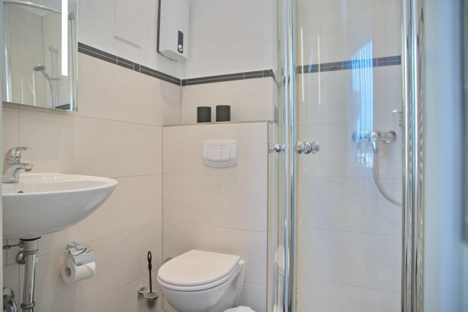 Badezimmer mit Dusche, Toilette und Waschbecken