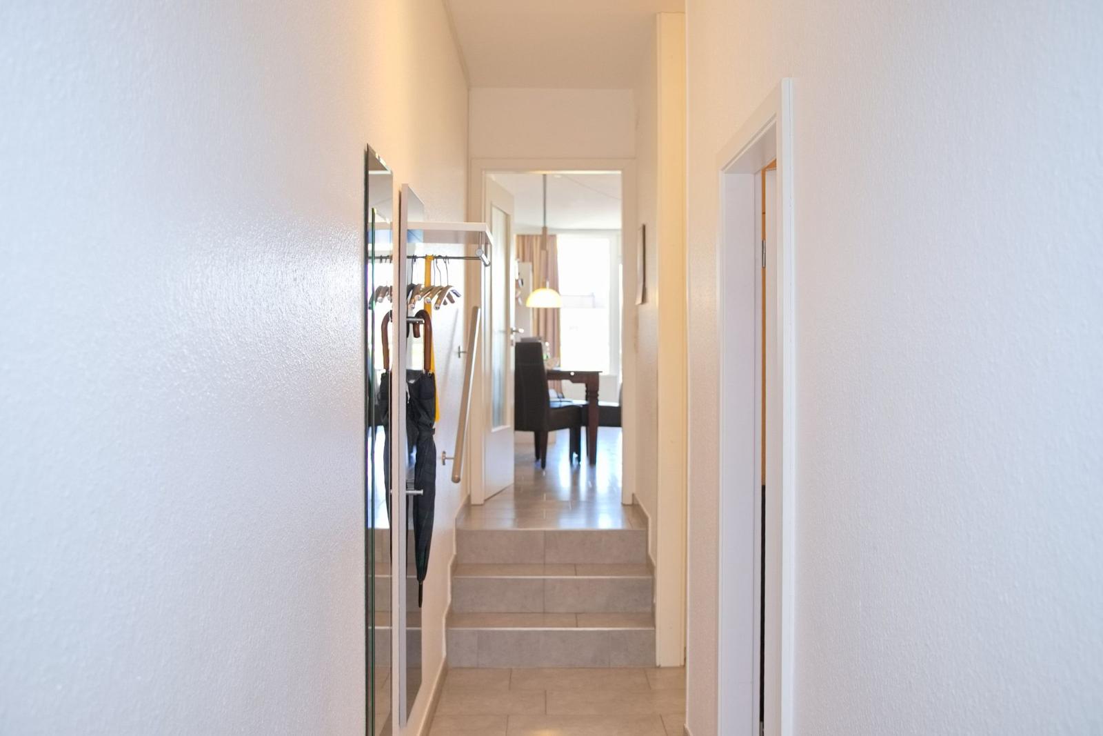 Flur mit Garderobe, Stufen und Blick in Esszimmer.