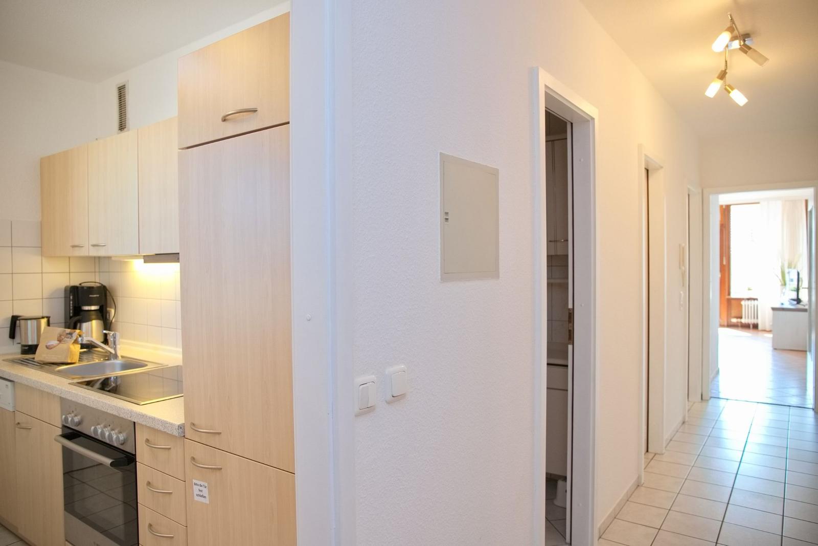 Küche mit Holzschränken und Blick in den Flur.