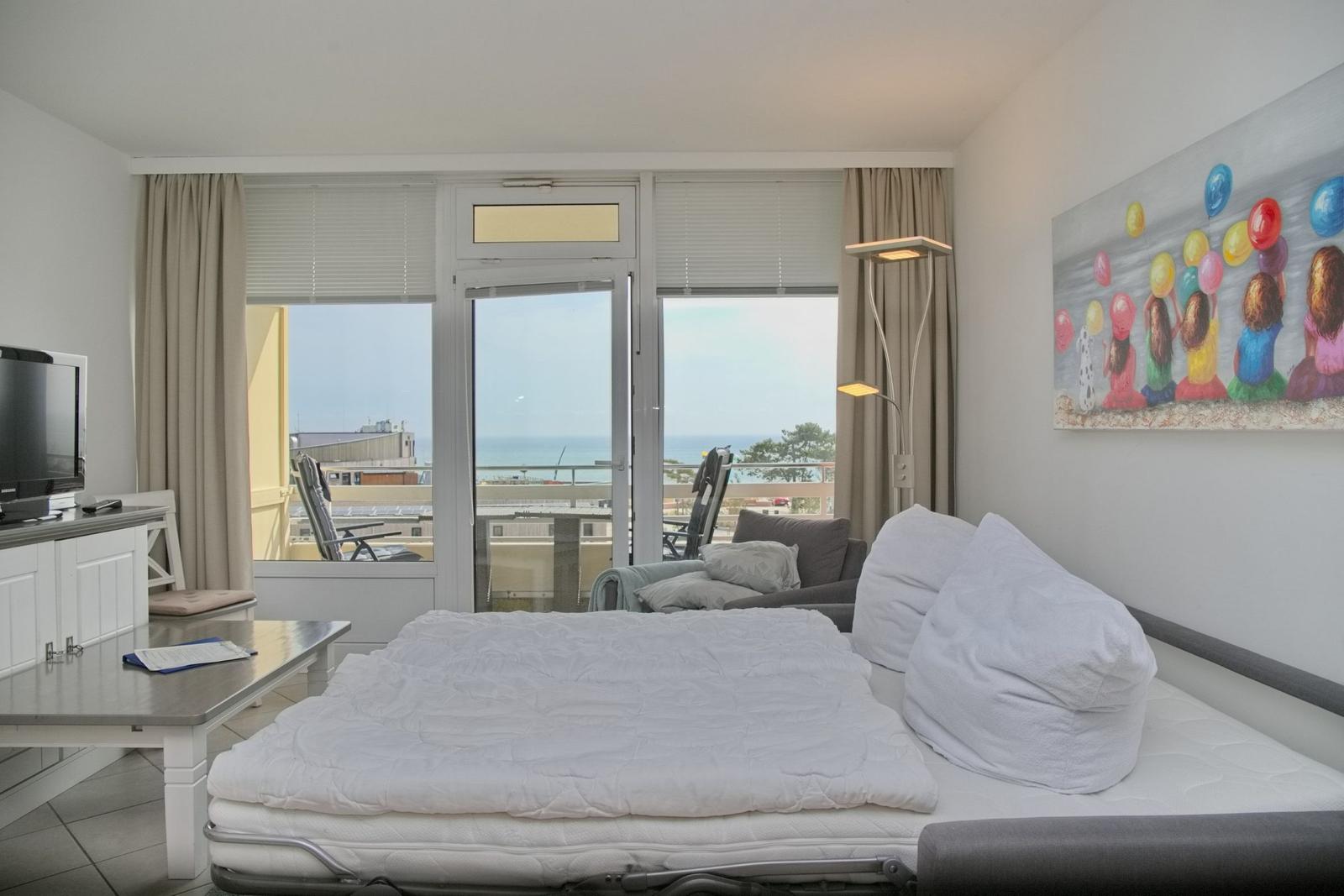 Schlafzimmer mit Blick auf den Strand und Balkon mit Liegestühlen.