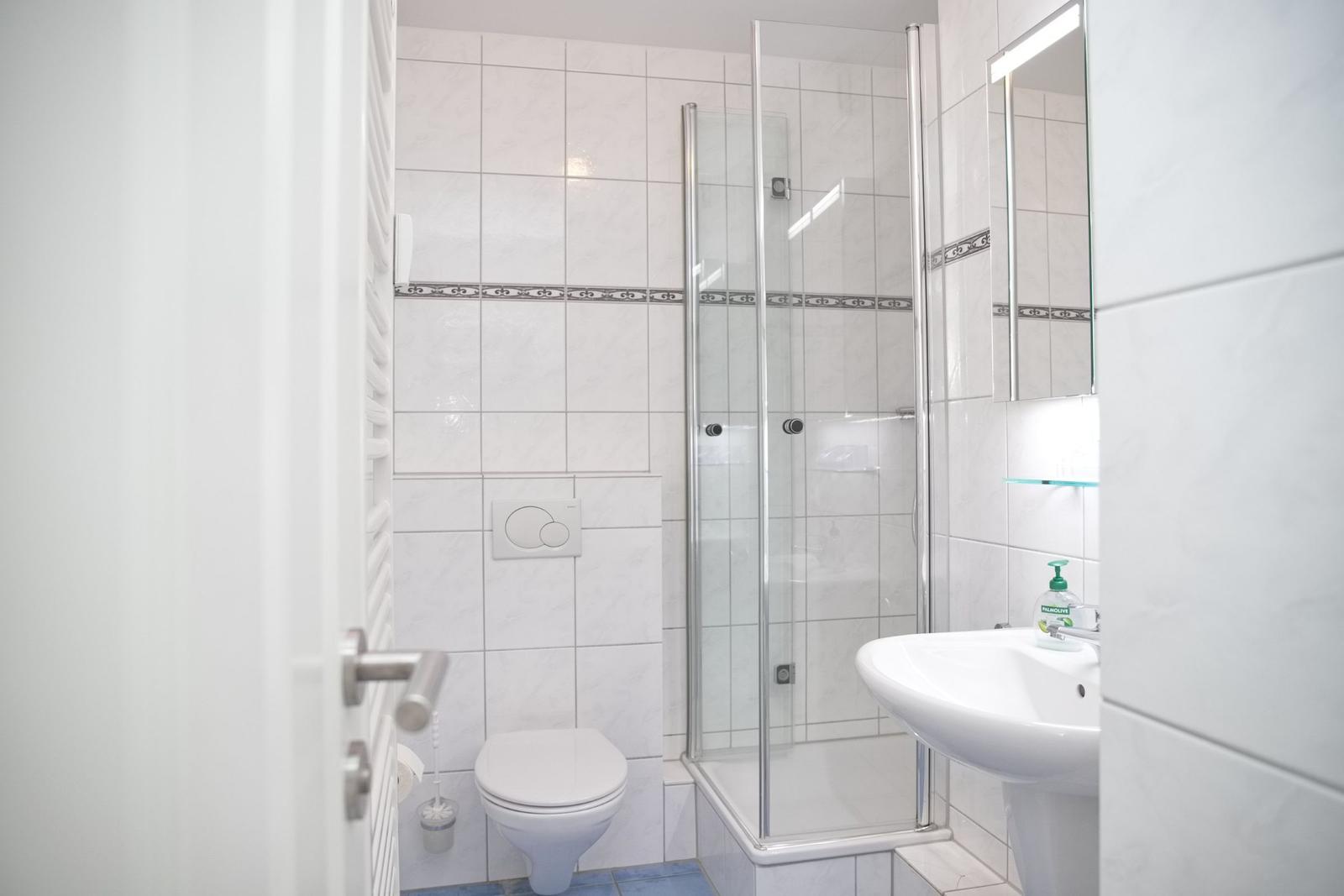 Badezimmer mit Dusche, Toilette und Waschbecken
