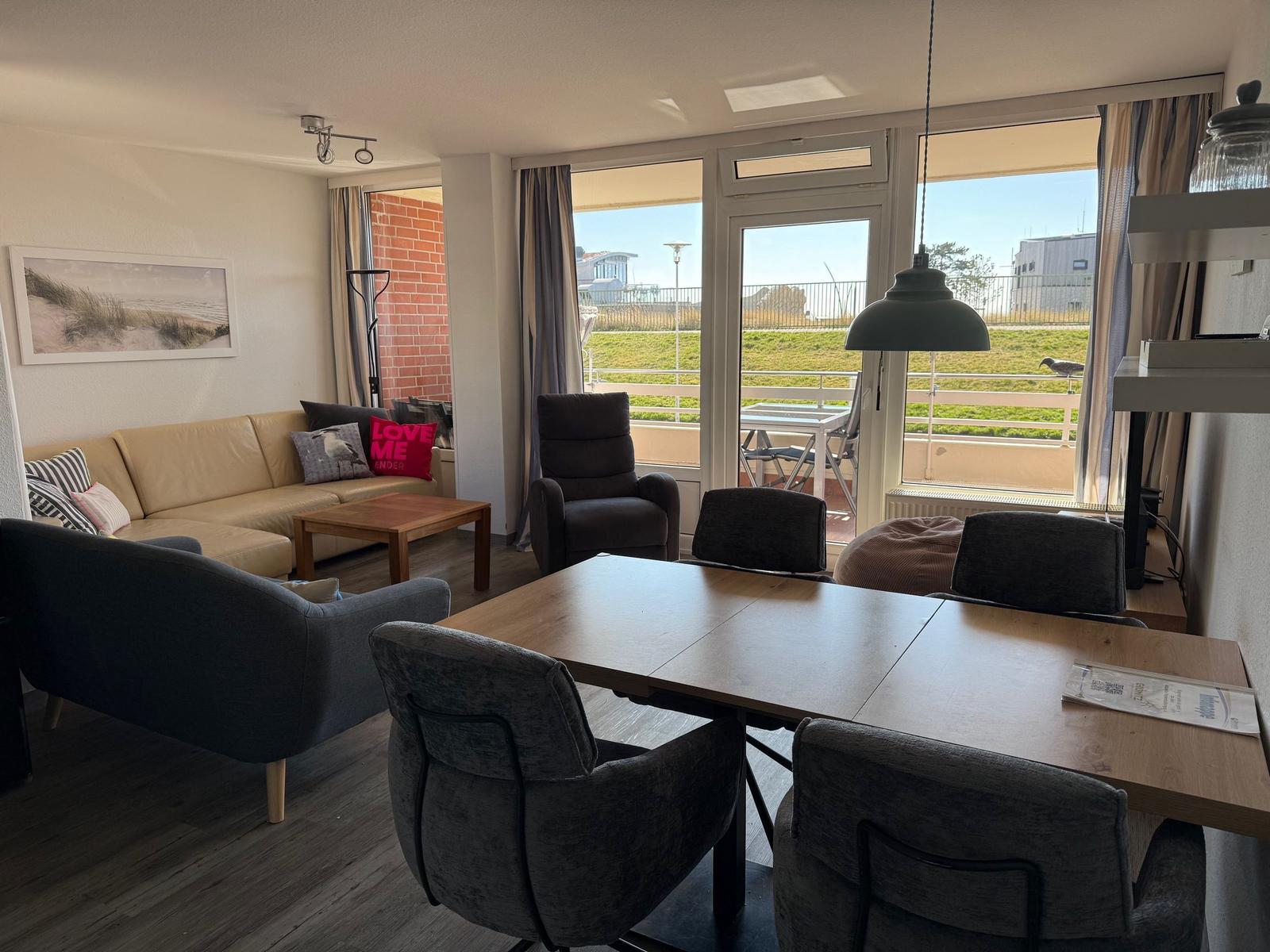 Wohn- und Essbereich mit Balkon. Möbel, Tisch und Stühle sichtbar.