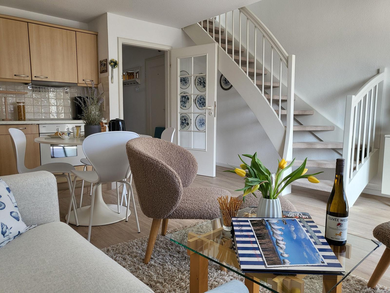 Wohnbereich mit Essbereich, Küche und Treppe zur oberen Etage.