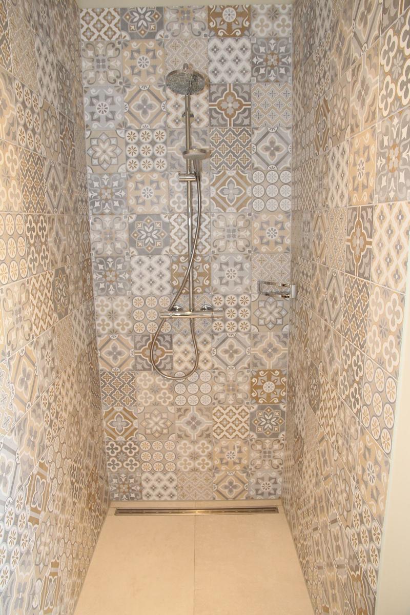 Dusche mit bunten Fliesen und Duschbrause