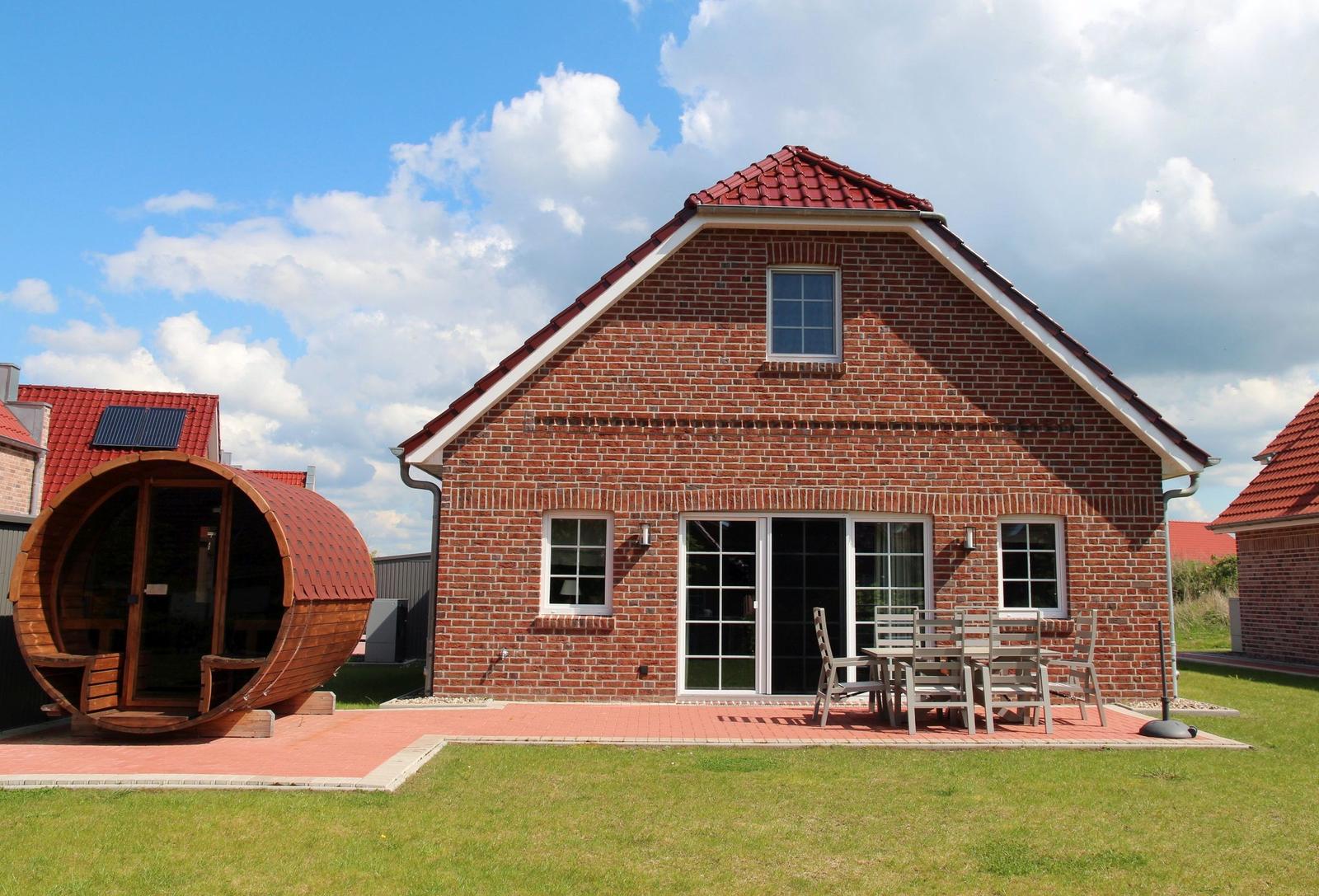 Rotes Ziegelhaus mit Terrasse, Garten und Holzsauna.