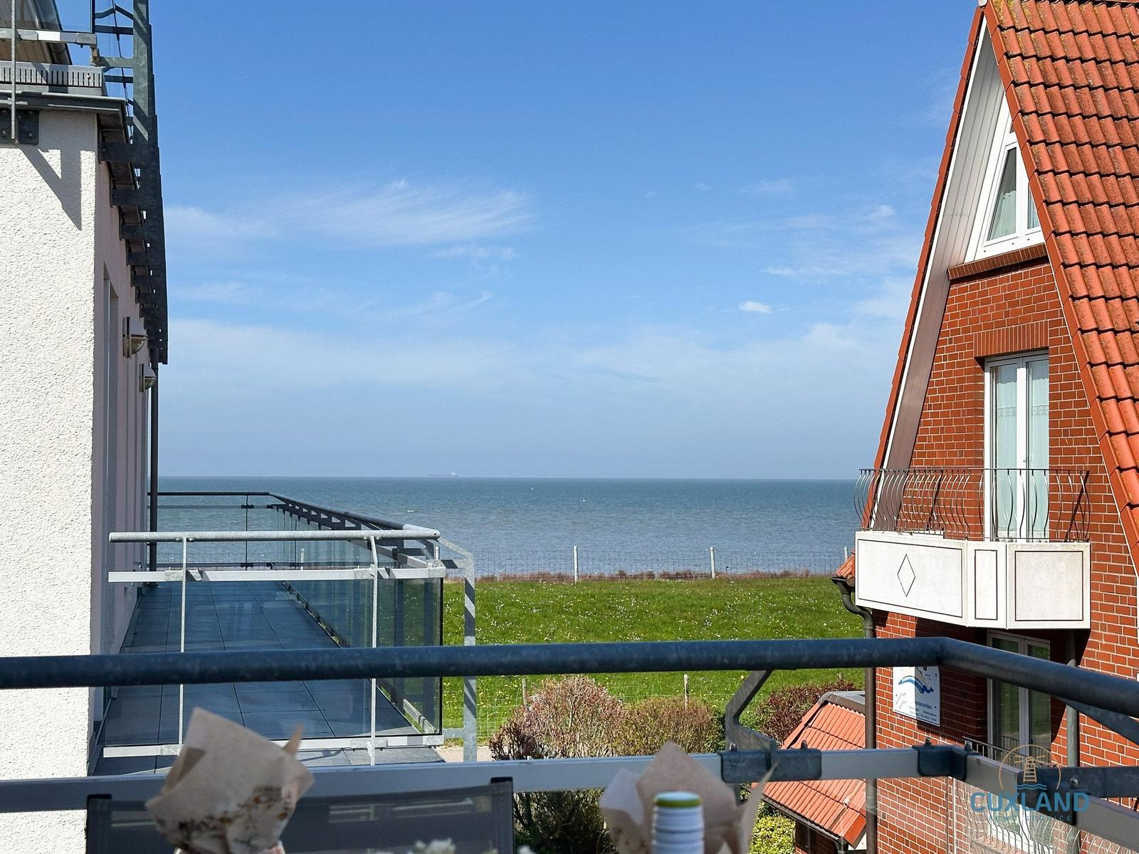 Balkon mit Meerblick, Grasfläche und rotem Dach